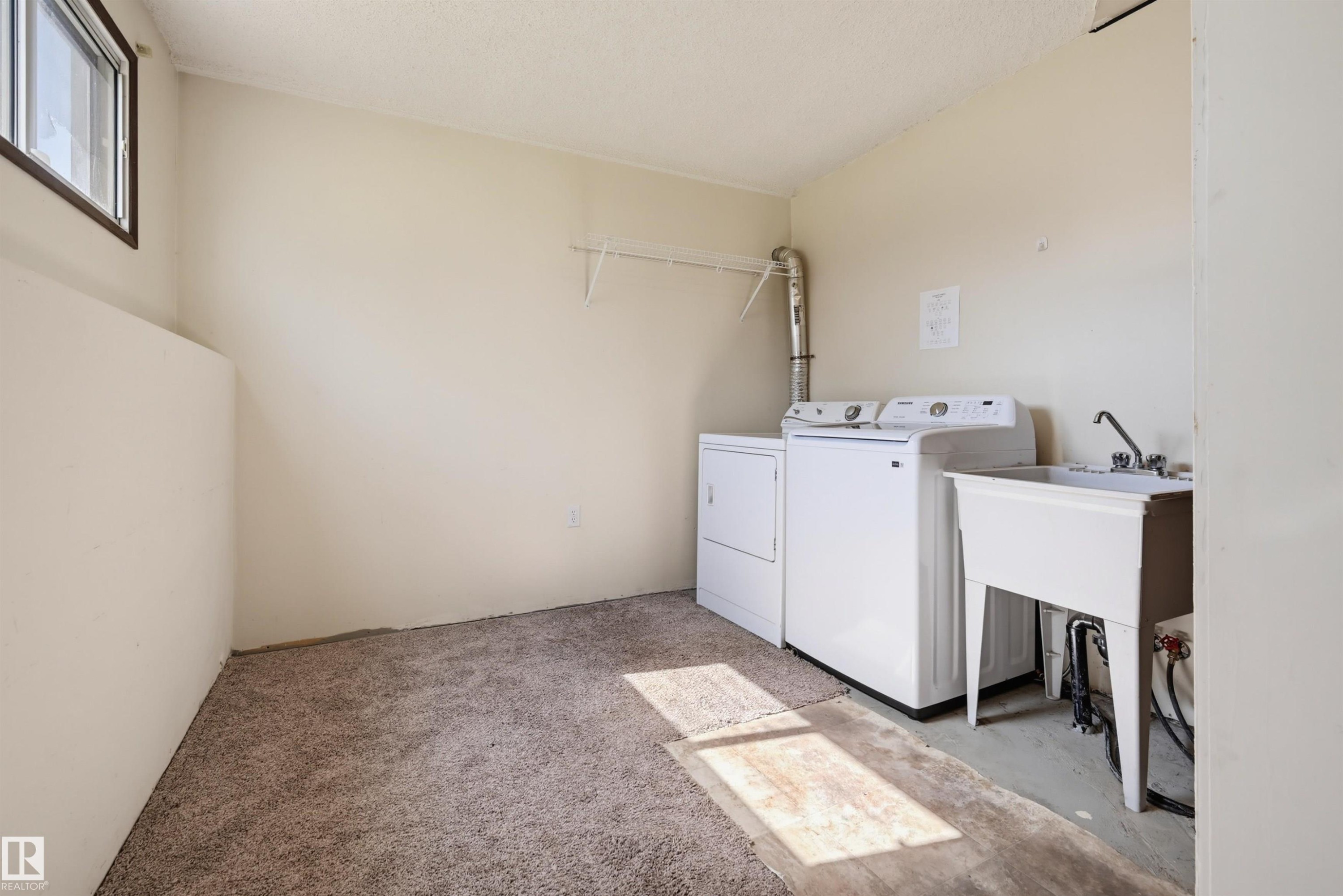 Laundry area featuring a utility sink, a washer, and a dryer - 6768 39 Avenue Nw, Edmonton, AB - Indoor Photo Showing Laundry Room