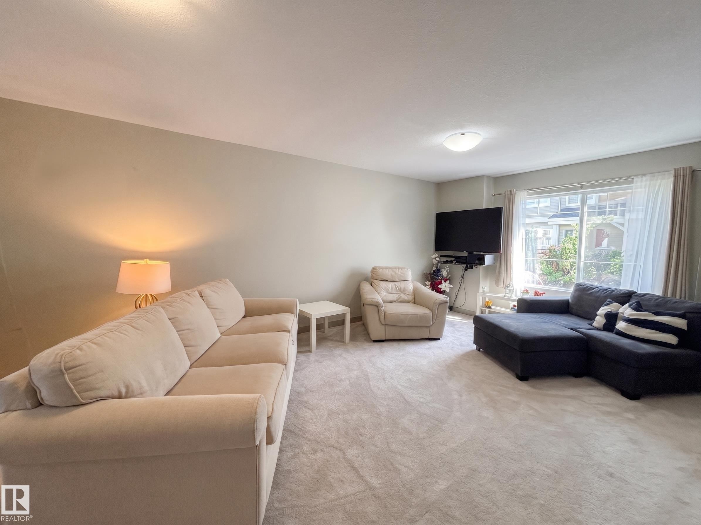 Wall-to-wall carpeting and neutral-toned walls - #29 1150 Windermere Wy Sw, Edmonton, AB