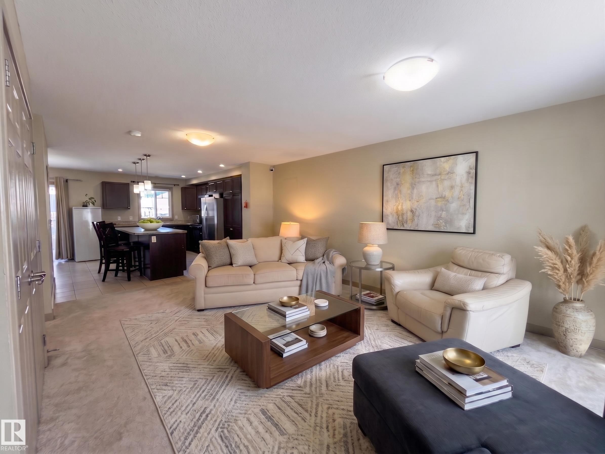 Open-concept living space with light-toned walls - #29 1150 Windermere Wy Sw, Edmonton, AB