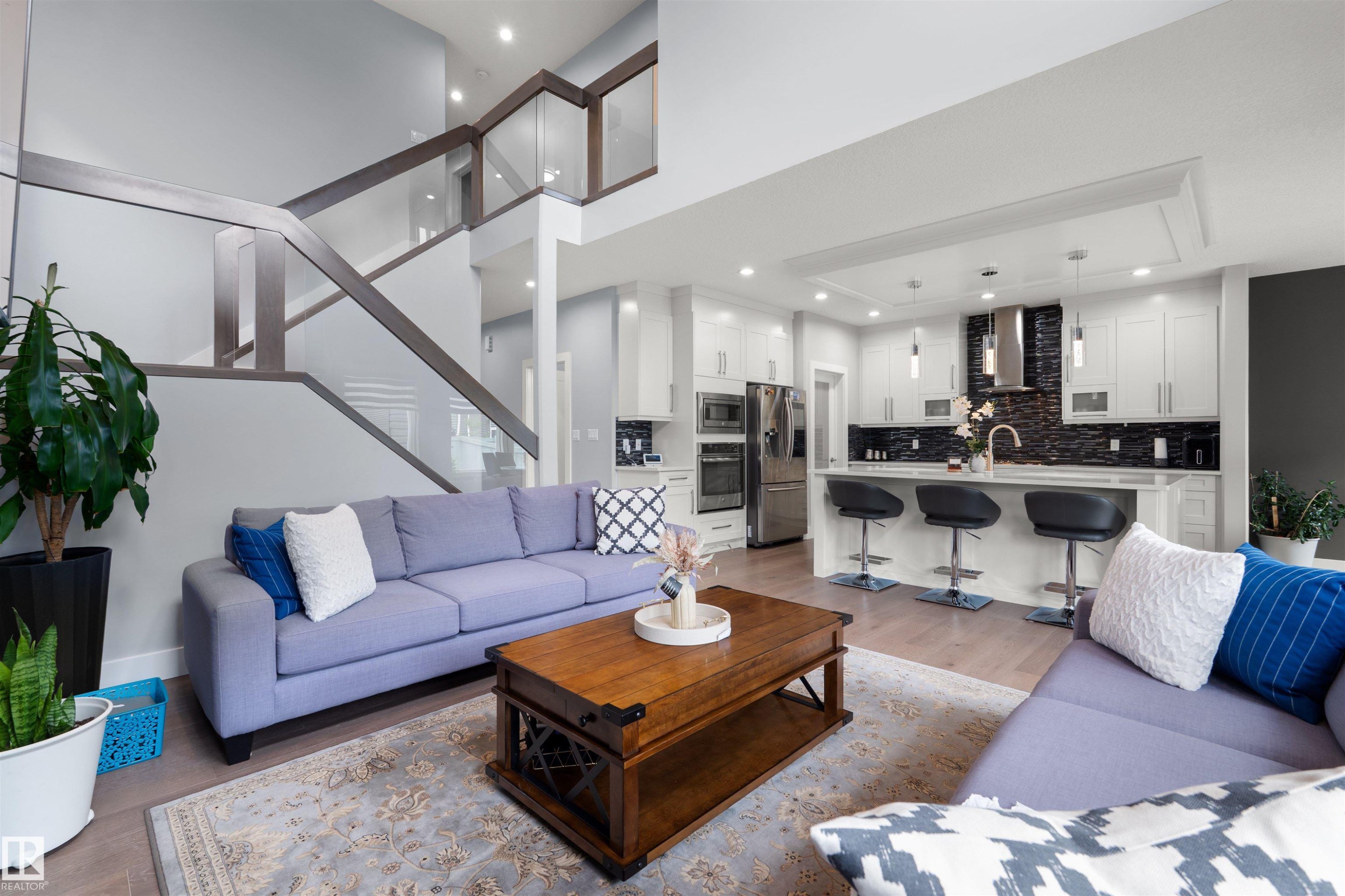 Open-concept living space featuring a modern kitchen with a large island and built-in stainless steel appliances - 16327 17 Avenue Sw, Edmonton, AB - Indoor Photo Showing Living Room