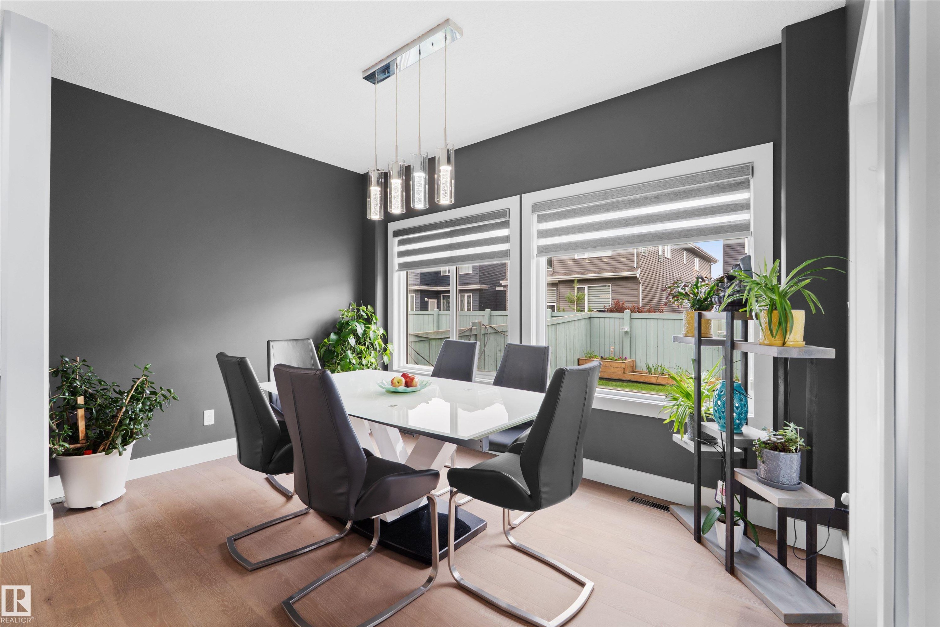 Wood-finish flooring, white trim, and dark accent walls - 16327 17 Avenue Sw, Edmonton, AB - Indoor Photo Showing Dining Room