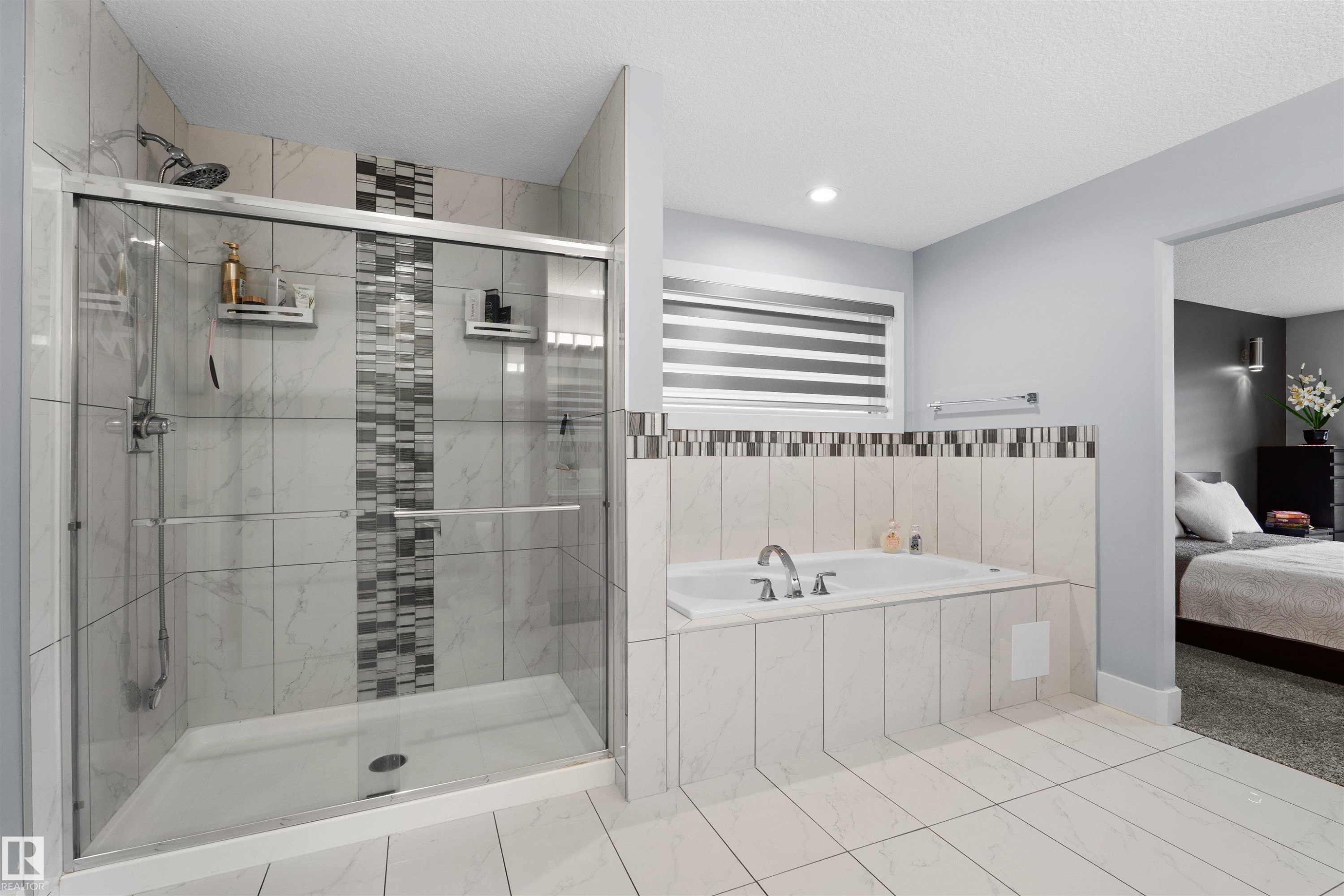 Glass-enclosed shower with a rainfall showerhead, and a built-in tub with chrome fixtures - 16327 17 Avenue Sw, Edmonton, AB - Indoor Photo Showing Bathroom