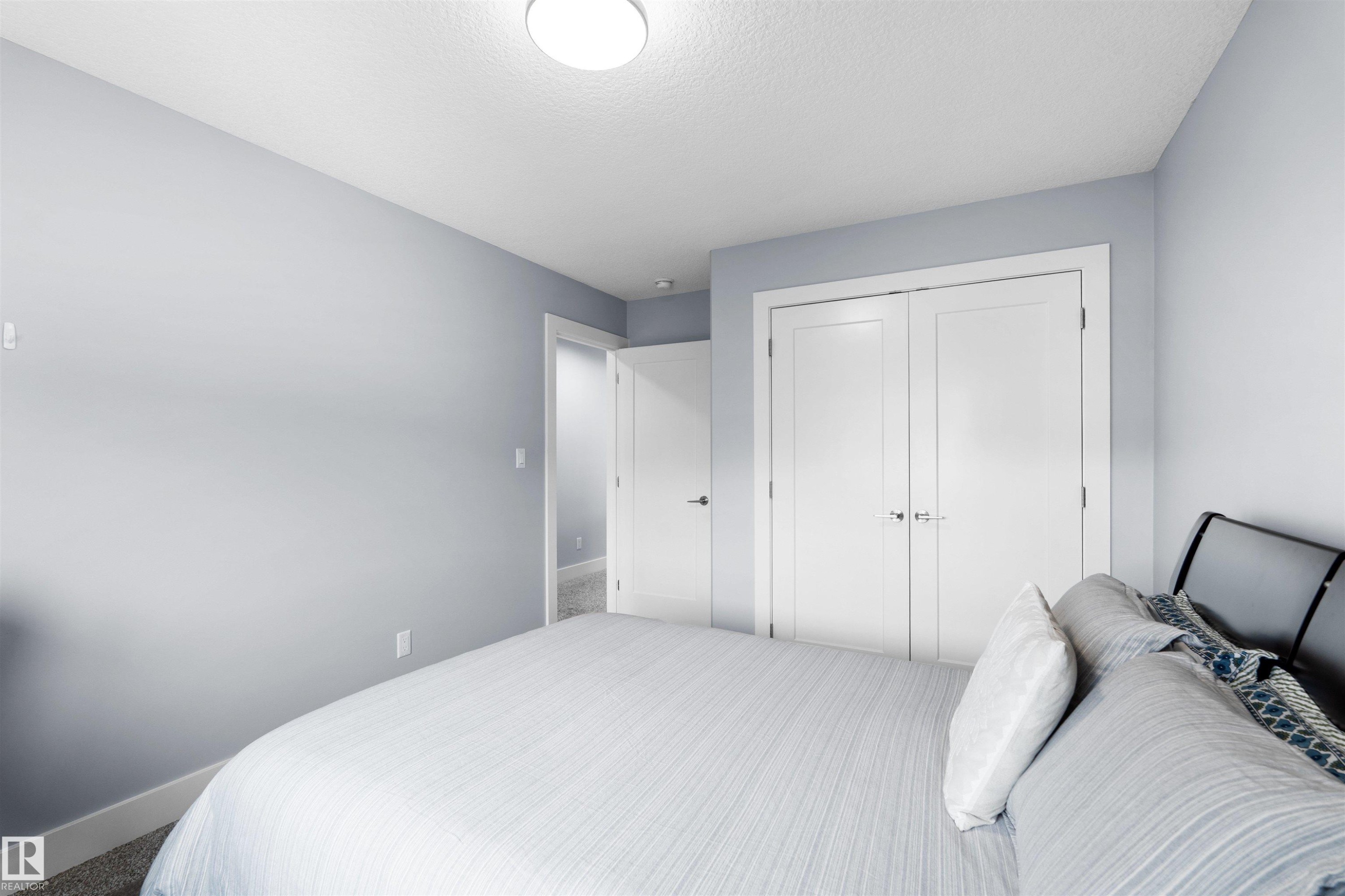 White double-door closet with chrome hardware - 16327 17 Avenue Sw, Edmonton, AB - Indoor Photo Showing Bedroom