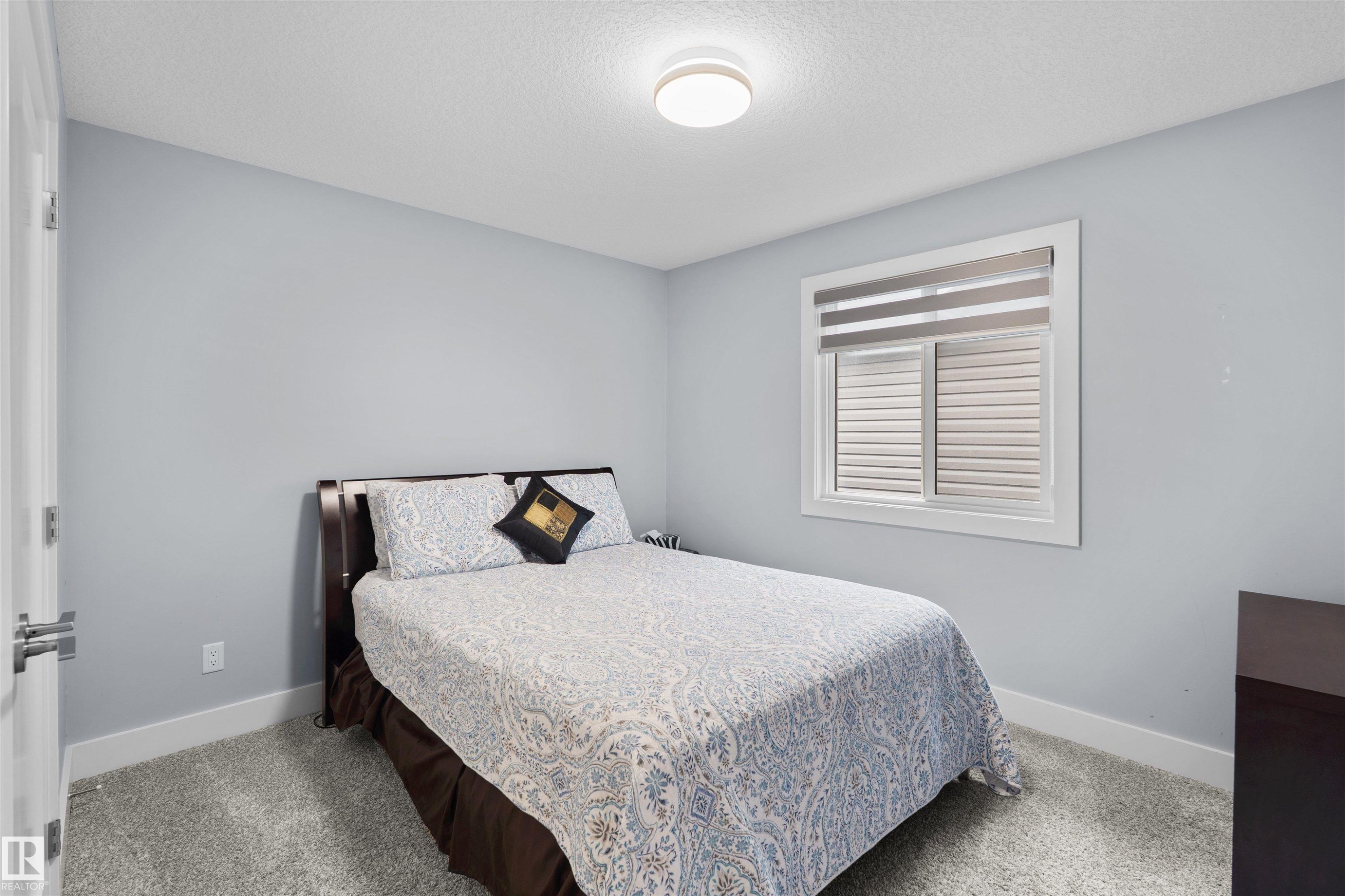 Window with horizontal blinds, flush mount ceiling light, and light gray wall paint - 16327 17 Avenue Sw, Edmonton, AB - Indoor Photo Showing Bedroom