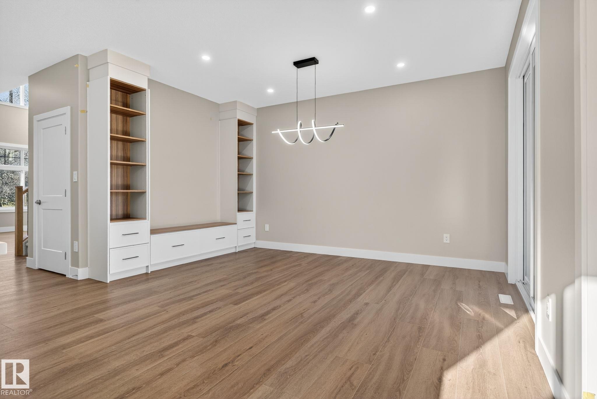 Wood-finish flooring throughout, complemented by a modern ceiling fixture and recessed lighting - 9736 73 Avenue Nw, Edmonton, AB