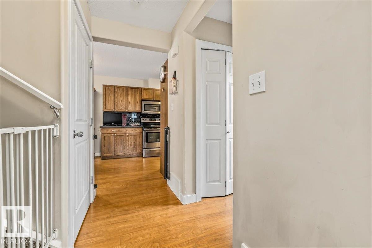 Kitchen featuring wood cabinetry, stainless steel appliances, and a black backsplash - 11436 88 Street Nw, Edmonton, AB - Indoor