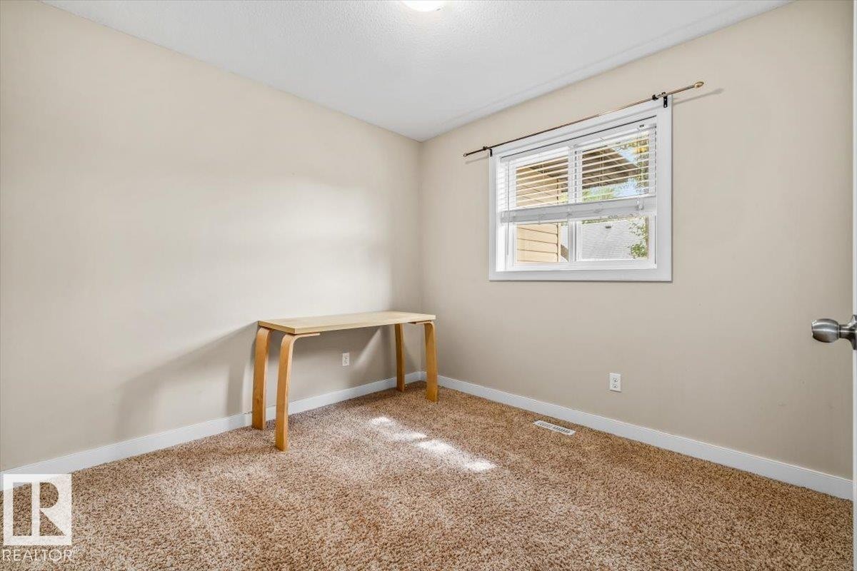 Neutral-toned carpeting, light-colored walls, and a window with blinds - 11436 88 Street Nw, Edmonton, AB - Indoor Photo Showing Other Room