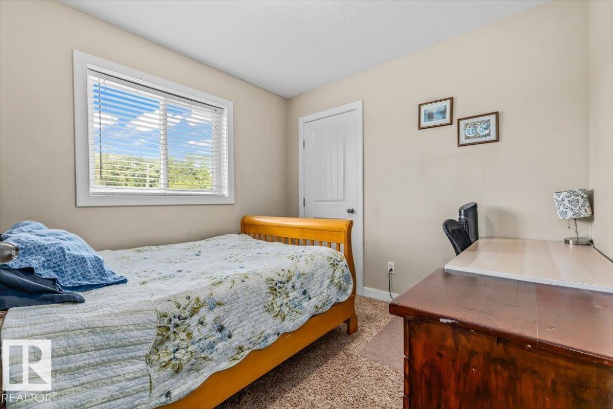 Neutral wall paint, white window trim, white interior door, and textured carpeting - 11436 88 Street Nw, Edmonton, AB - Indoor Photo Showing Bedroom