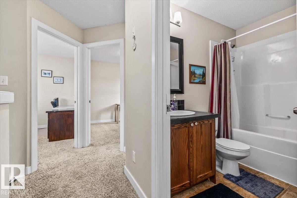 Bathroom featuring a wood-finish vanity with an integrated sink and a shower-over-tub combination - 11436 88 Street Nw, Edmonton, AB - Indoor Photo Showing Bathroom