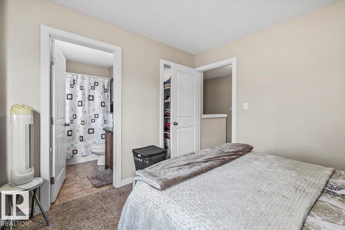 Integrated closet with shelving, neutral wall paint, and carpeted flooring - 11436 88 Street Nw, Edmonton, AB - Indoor Photo Showing Bedroom