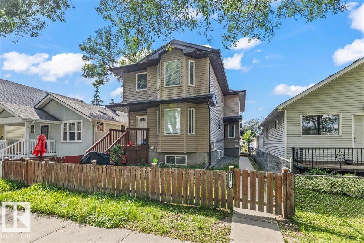 Multi-level home with bay windows, siding exterior, and a wooden privacy fence - 11436 88 Street Nw, Edmonton, AB - Outdoor