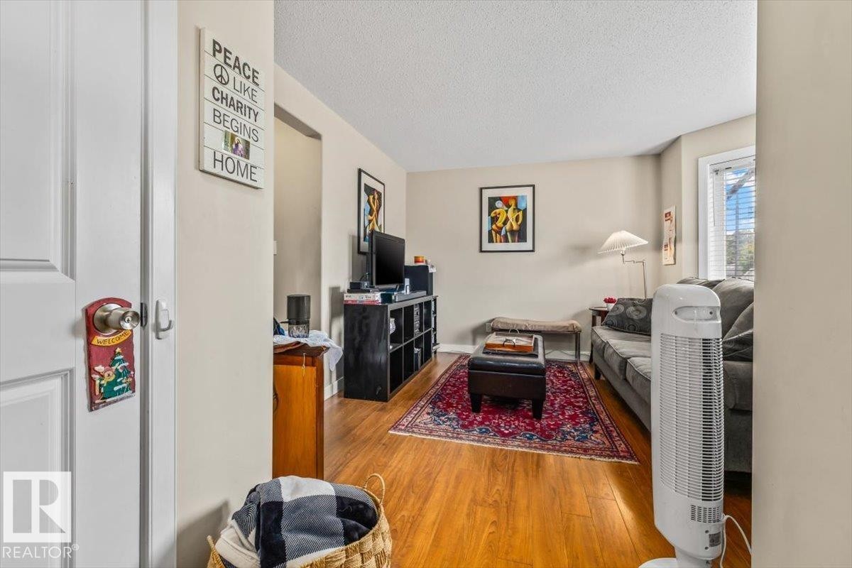 Wood-finish flooring throughout the room, complemented by neutral wall tones - 11436 88 Street Nw, Edmonton, AB - Indoor