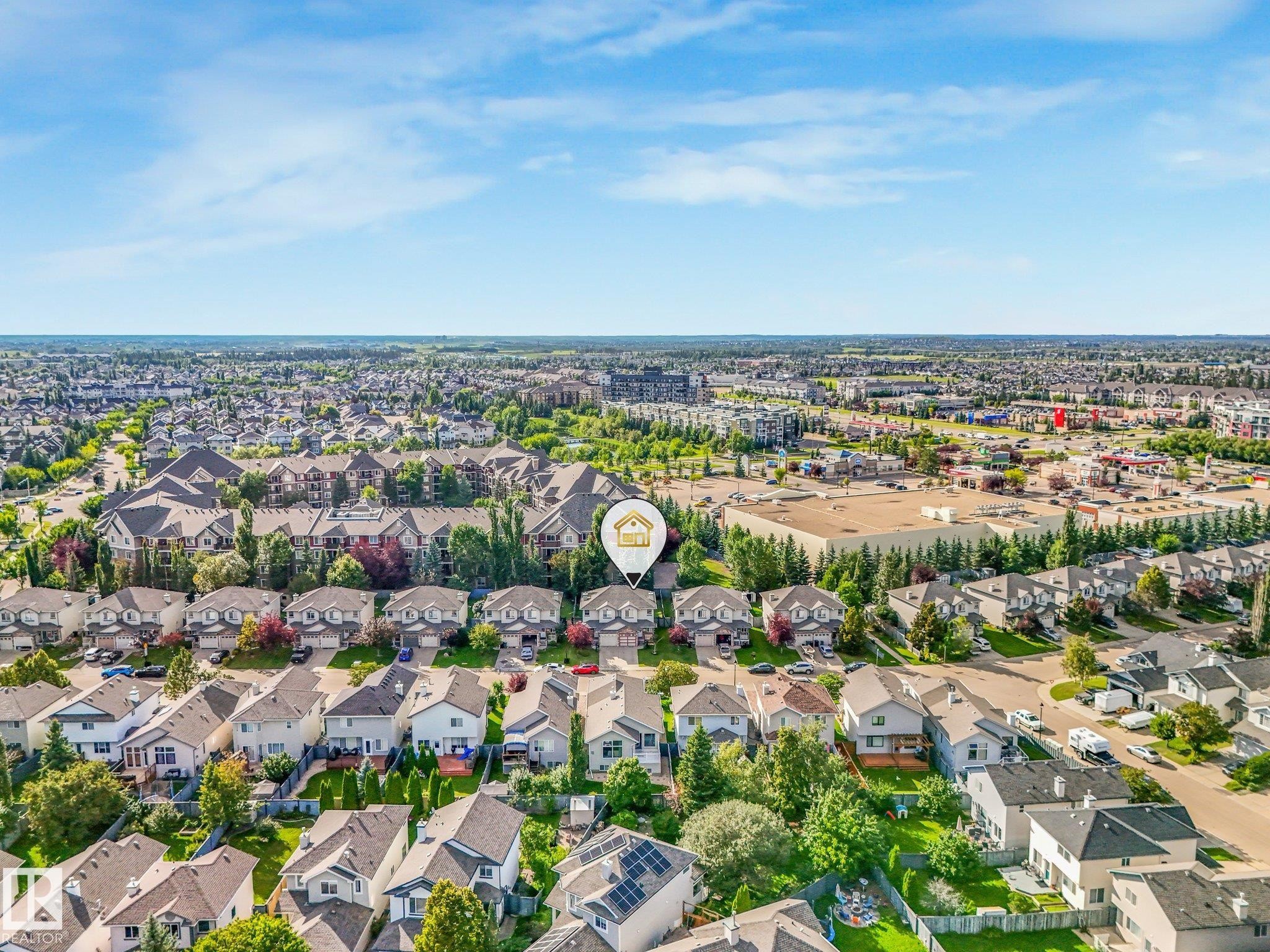 Expansive residential area with a mix of housing styles, established landscaping, and commercial properties in the distance - 1142 Barnes Way Sw, Edmonton, AB - Outdoor With View
