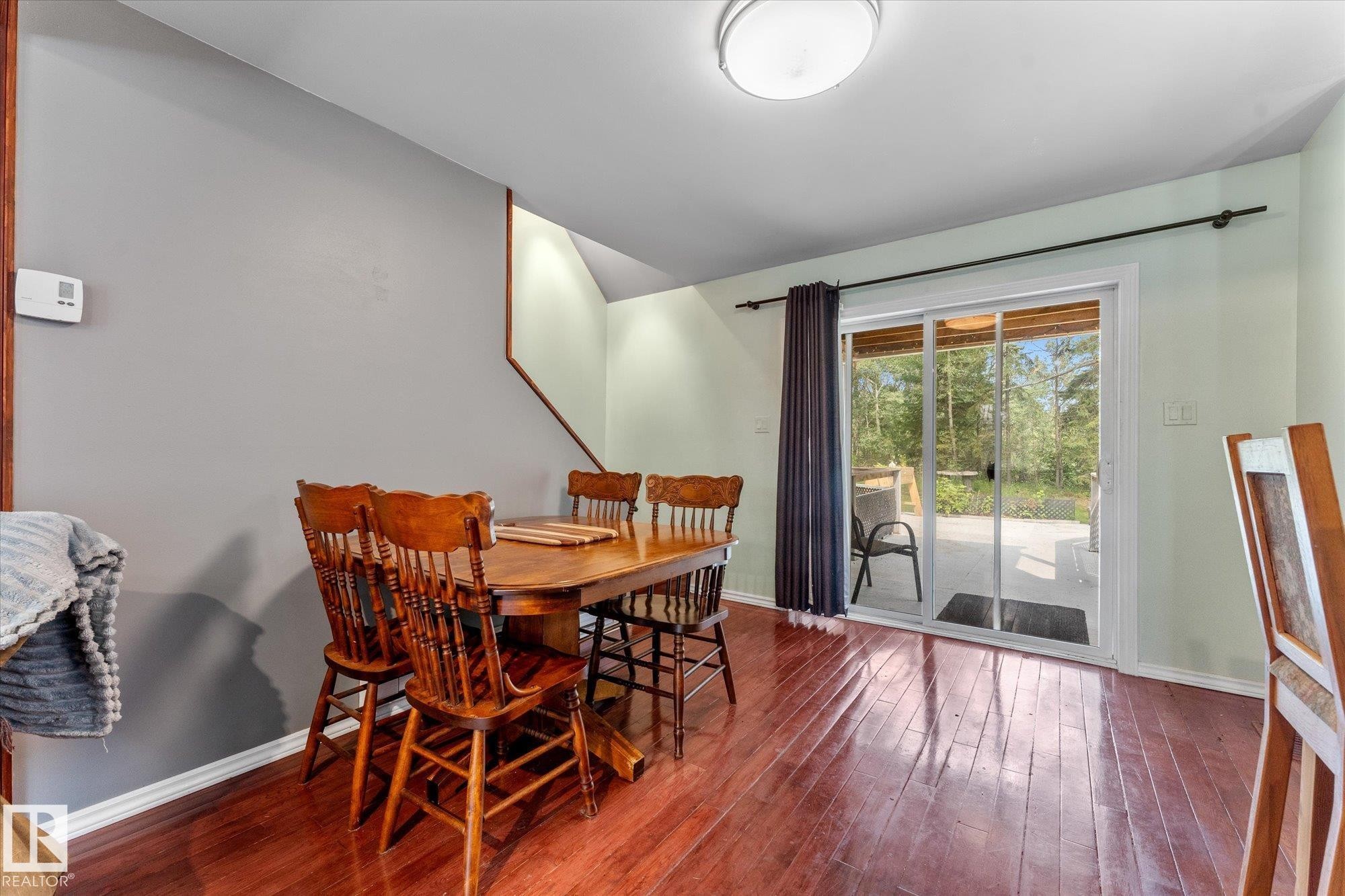 Floors are Bruce oak Harwood flooring throughout dining and living area , bright sliding glass door to the exterior, and a built-in ceiling light fixture - 2, 59031 Range Rd 232, Rural Thorhild County, AB - Indoor Photo Showing Dining Room