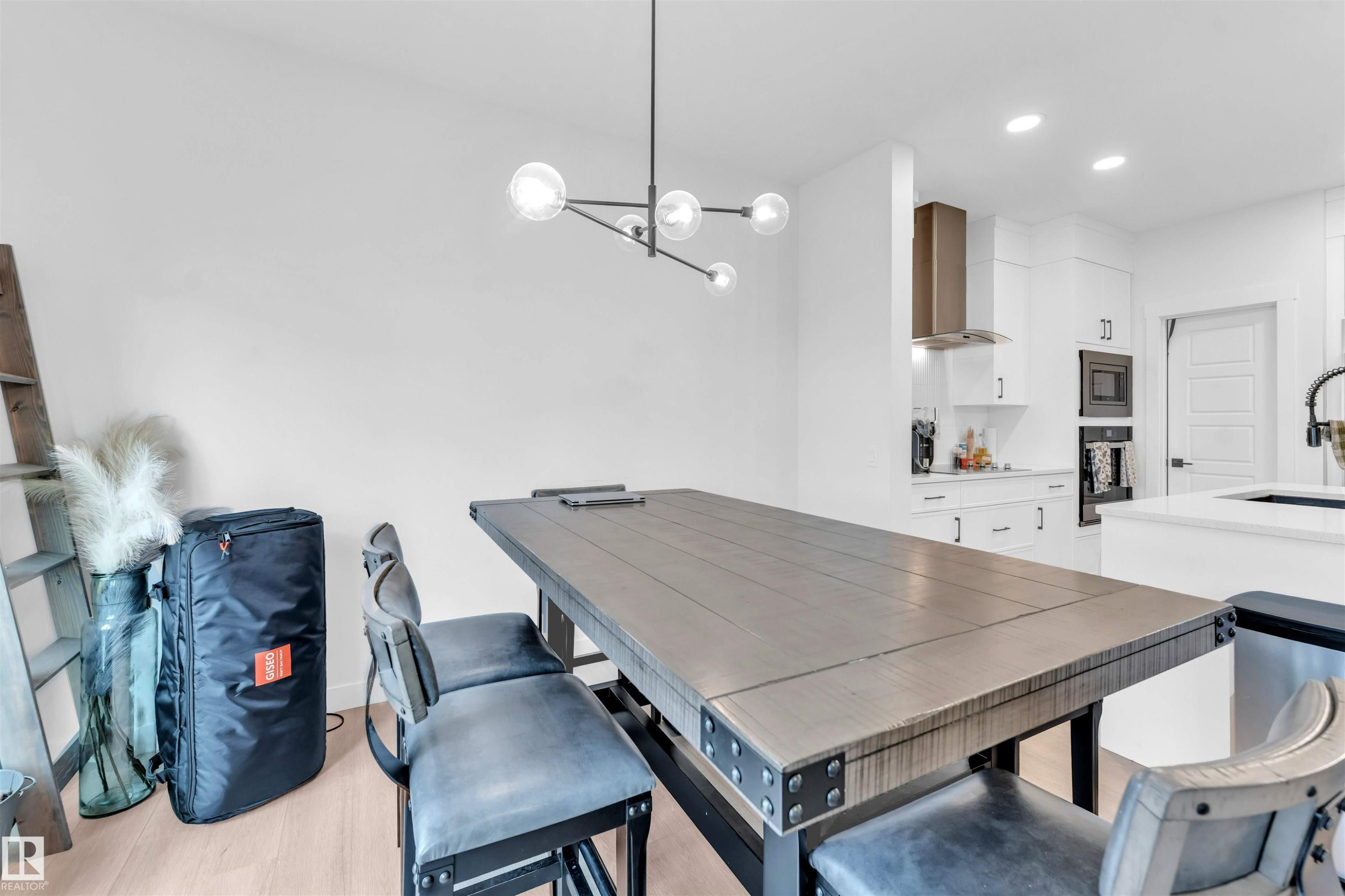 Recessed lighting, wood-finish flooring, white cabinetry, stainless steel range hood, built-in microwave - 3236 Chernowski Way Sw, Edmonton, AB - Indoor