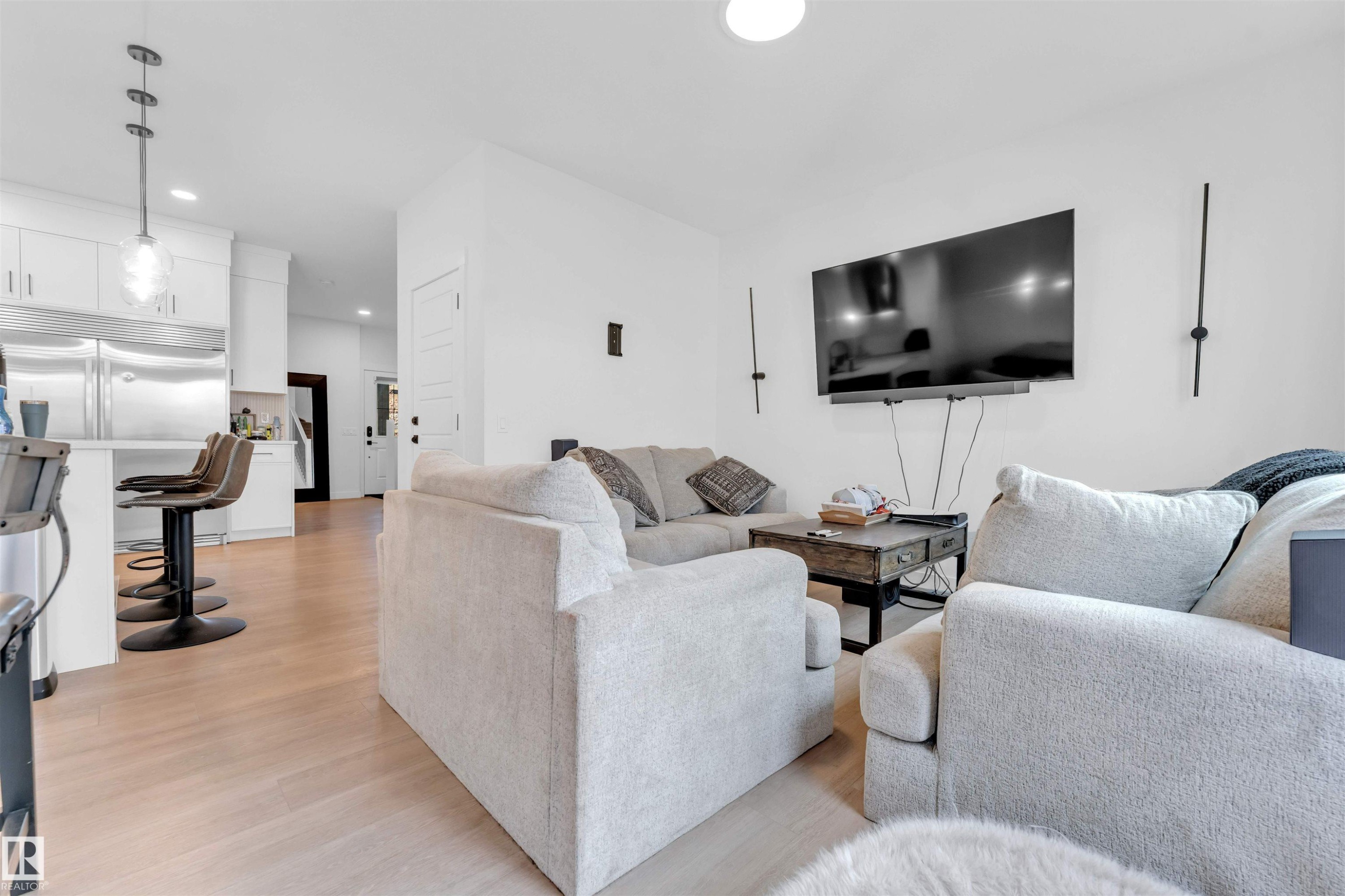 Open-concept living area featuring light wood-finish flooring, white walls, and recessed lighting - 3236 Chernowski Way Sw, Edmonton, AB - Indoor Photo Showing Living Room