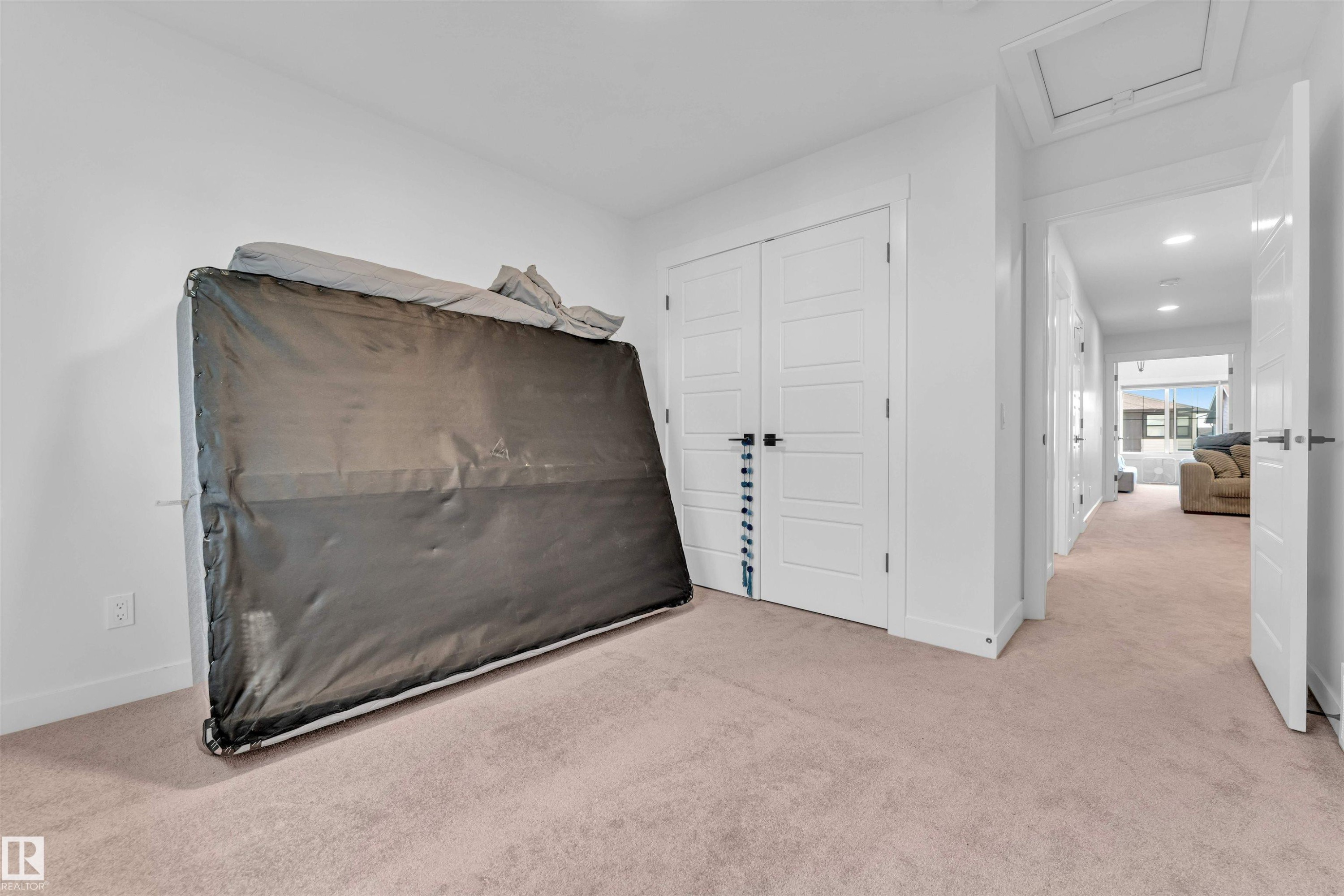 White paneled doors with matte black hardware, recessed ceiling lighting, and light-toned carpeting - 3236 Chernowski Way Sw, Edmonton, AB - Indoor