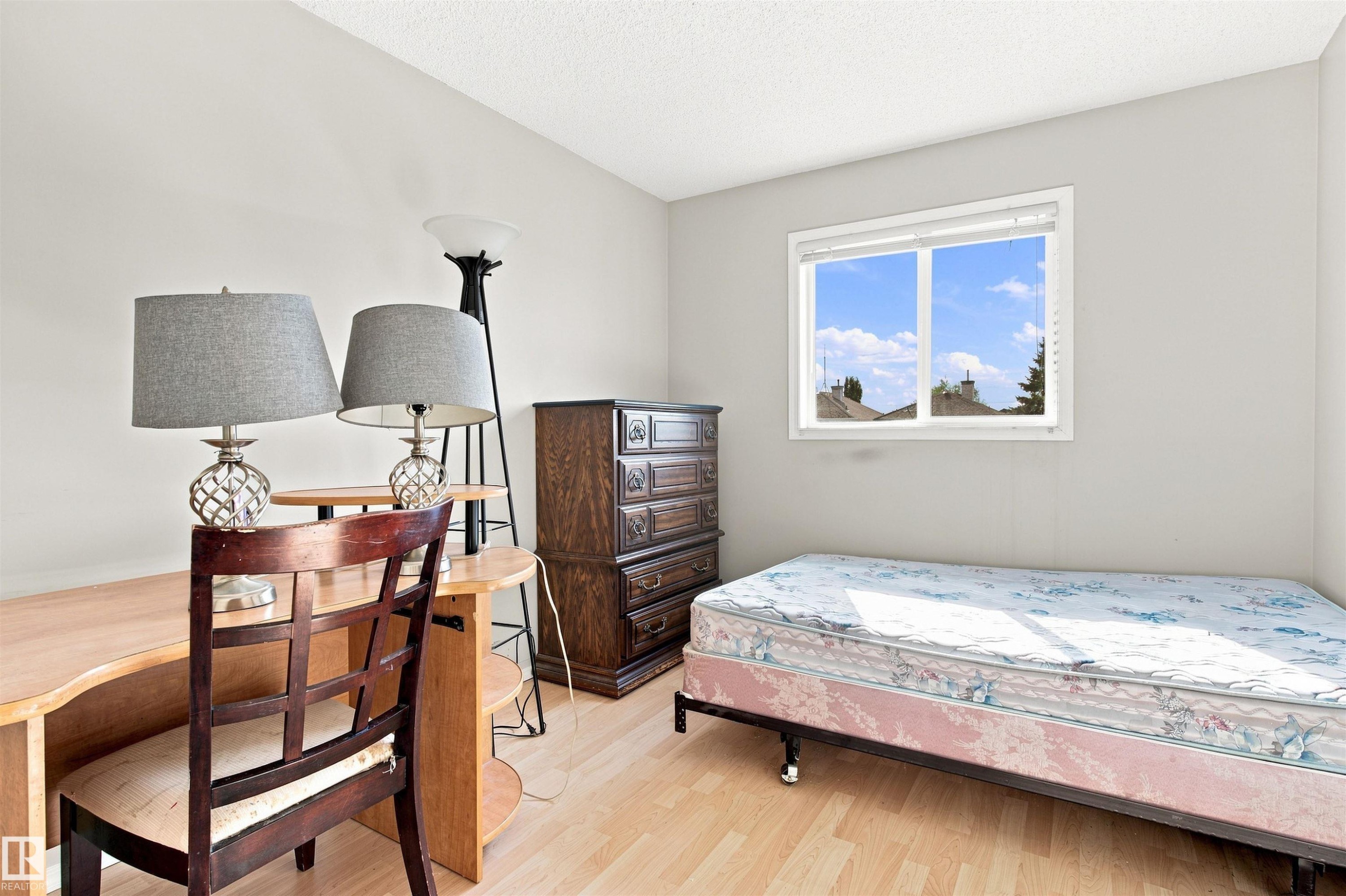 Light-toned wood-finish flooring, white walls, and a single window with white trim - 204 84 Street Sw, Edmonton, AB - Indoor Photo Showing Bedroom
