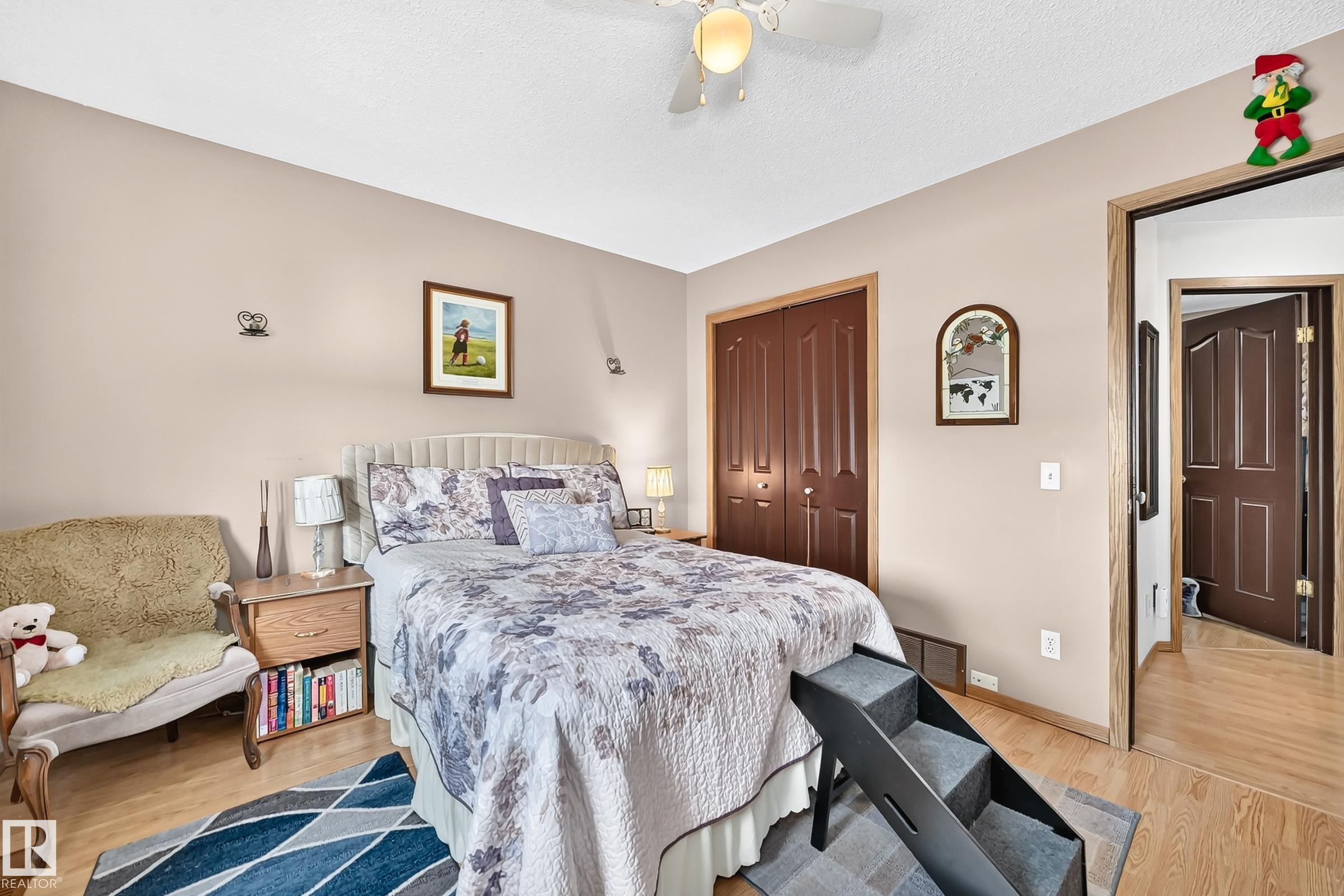 Light wood-finish flooring, built-in dual door closet, ceiling fan, and painted walls - 13069 37 Street Nw, Edmonton, AB - Indoor Photo Showing Bedroom