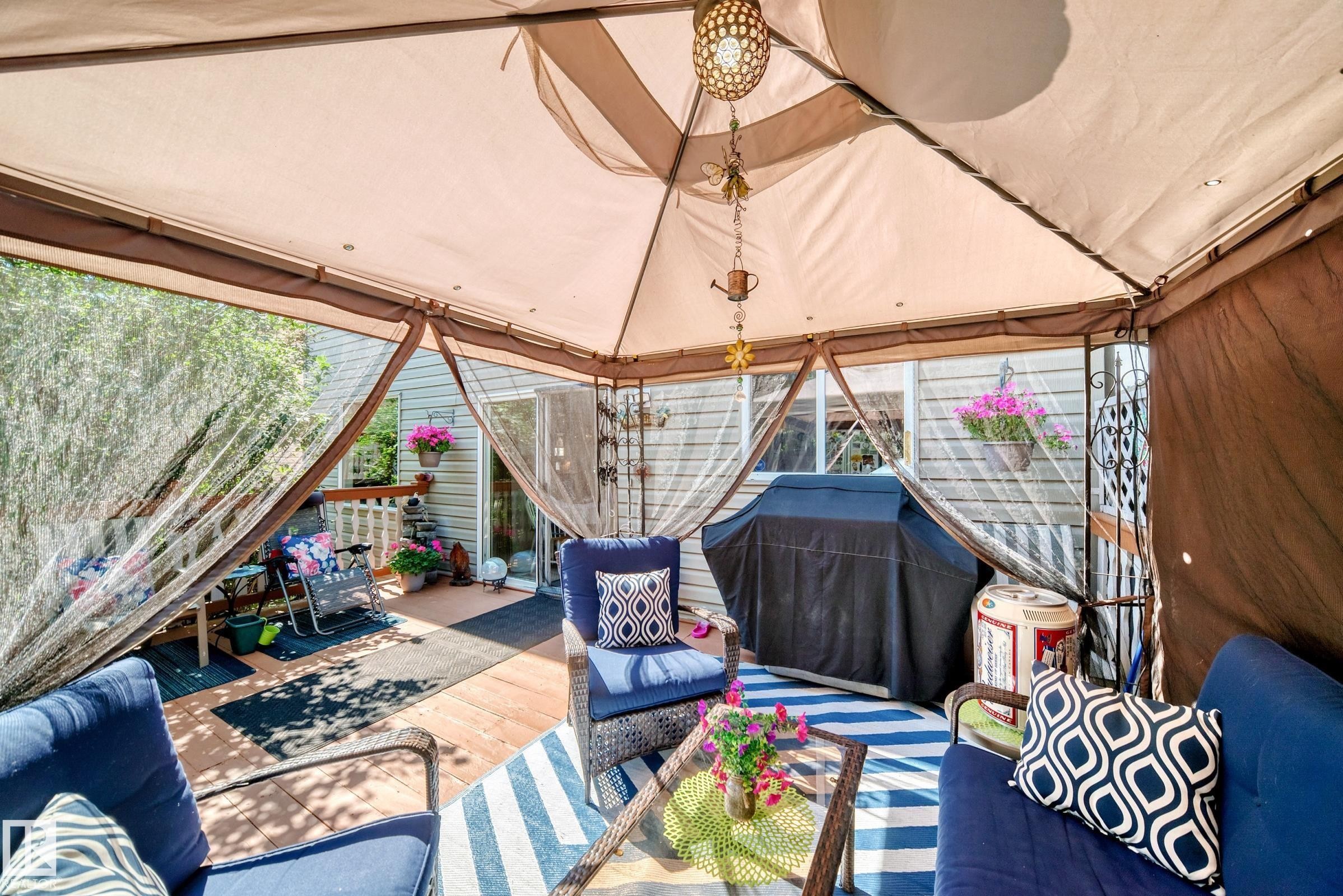 Spacious outdoor deck featuring wood-finish flooring, a gazebo canopy, and a sliding glass door entry - 13069 37 Street Nw, Edmonton, AB - Photo Showing Other Room