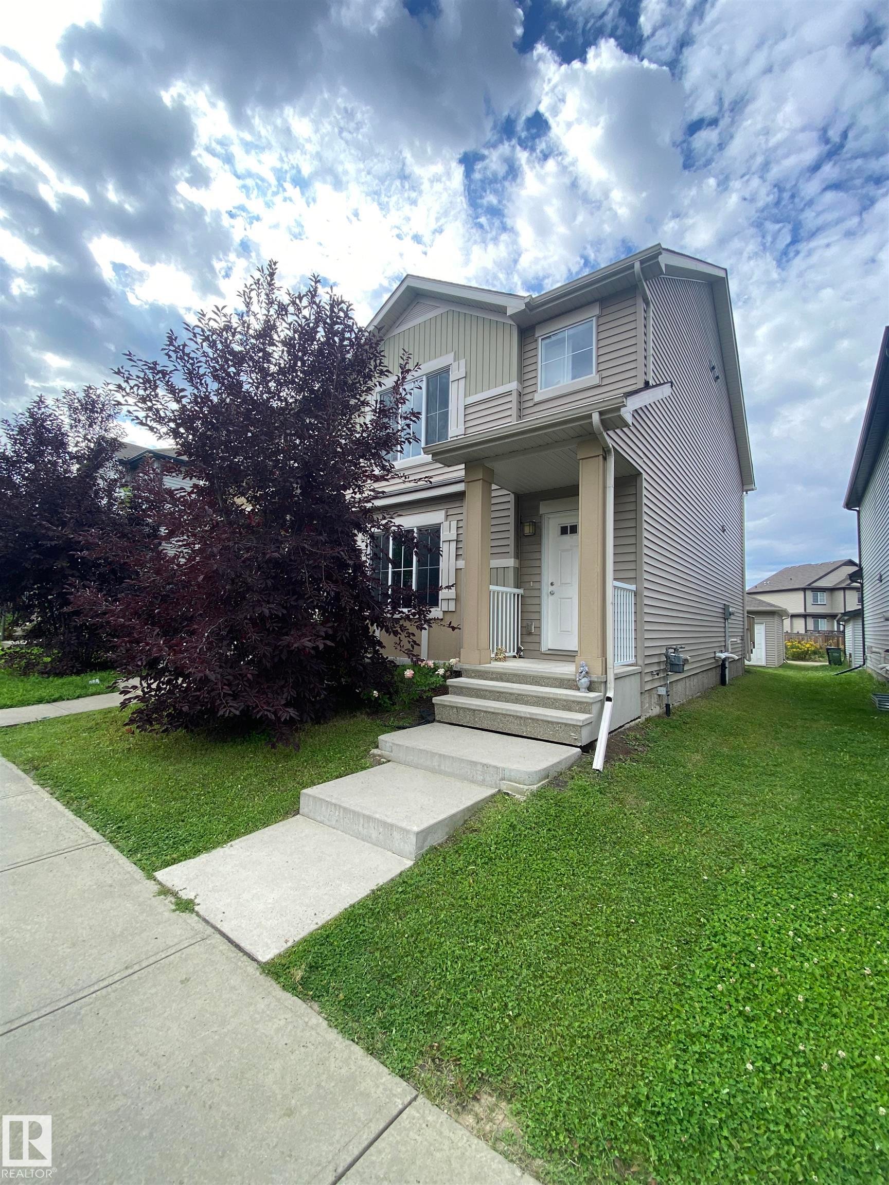 Two-story exterior with light-toned siding, concrete walkway, concrete porch steps, and a covered entry - 308 Watt Boulevard Sw, Edmonton, AB - Outdoor