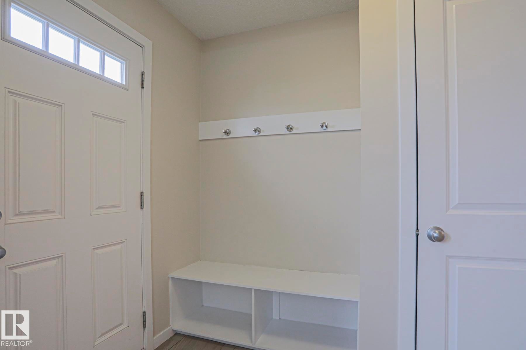Entryway mudroom with a built-in bench, storage cubbies, and wall-mounted coat hooks - 308 Watt Boulevard Sw, Edmonton, AB - Indoor Photo Showing Other Room