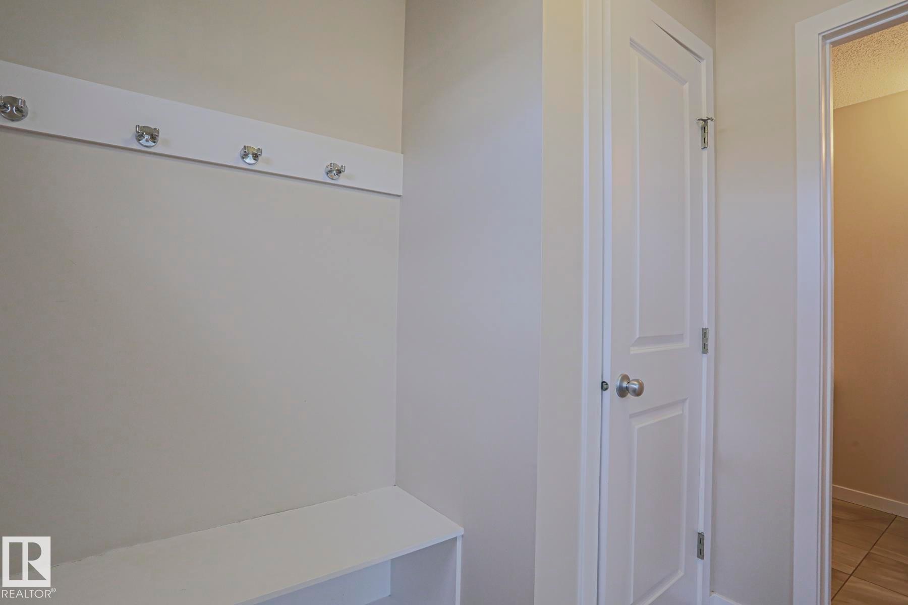 Built-in bench with integrated shelving and wall-mounted coat rack - 308 Watt Boulevard Sw, Edmonton, AB - Indoor Photo Showing Other Room