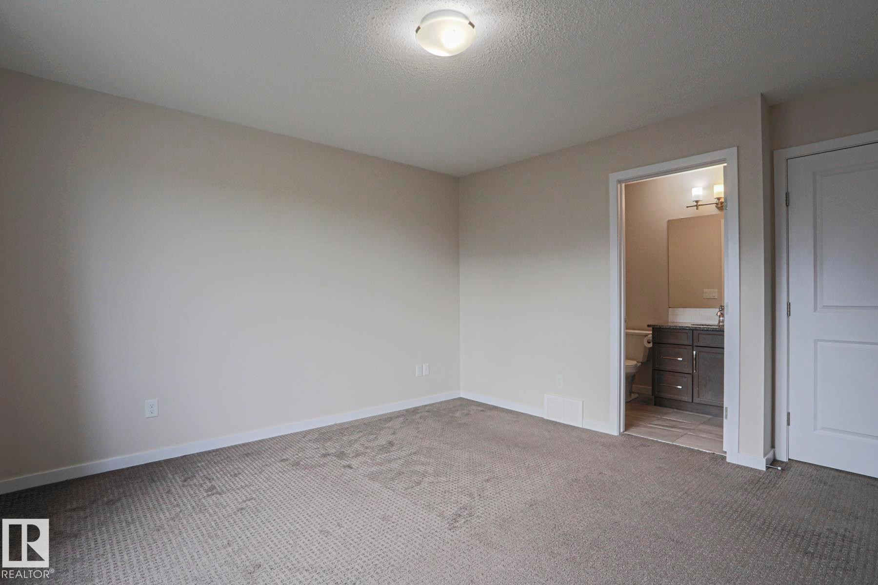 Carpeted room with a flush-mount ceiling light and a white paneled door - 308 Watt Boulevard Sw, Edmonton, AB - Indoor Photo Showing Other Room