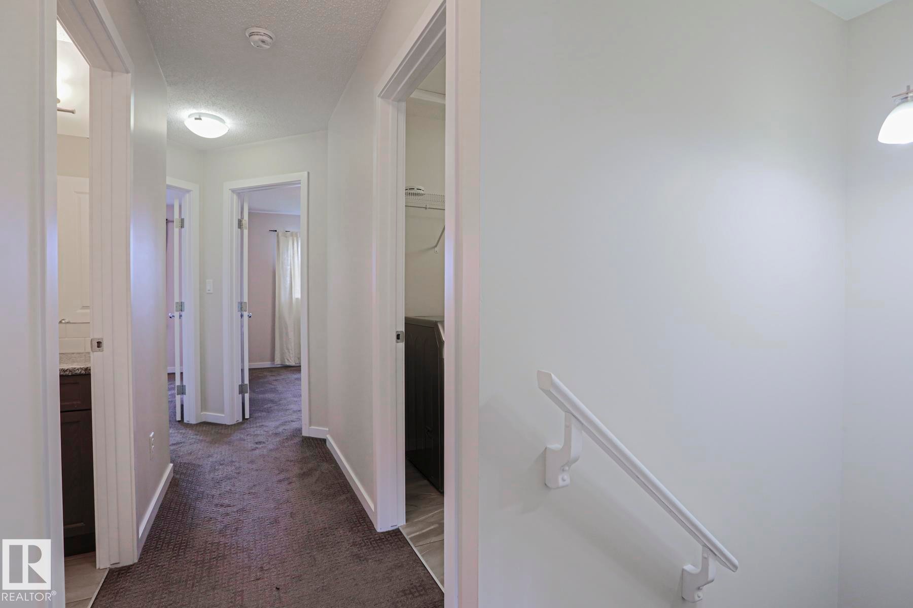 Hallway with recessed lighting, textured ceilings, white trim, and gray carpet flooring - 308 Watt Boulevard Sw, Edmonton, AB - Indoor Photo Showing Other Room