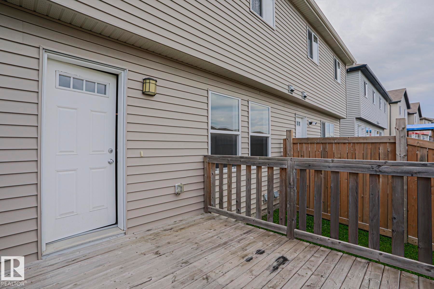 Exterior deck with wood fencing, vinyl siding, and transom window door - 308 Watt Boulevard Sw, Edmonton, AB - Outdoor With Exterior