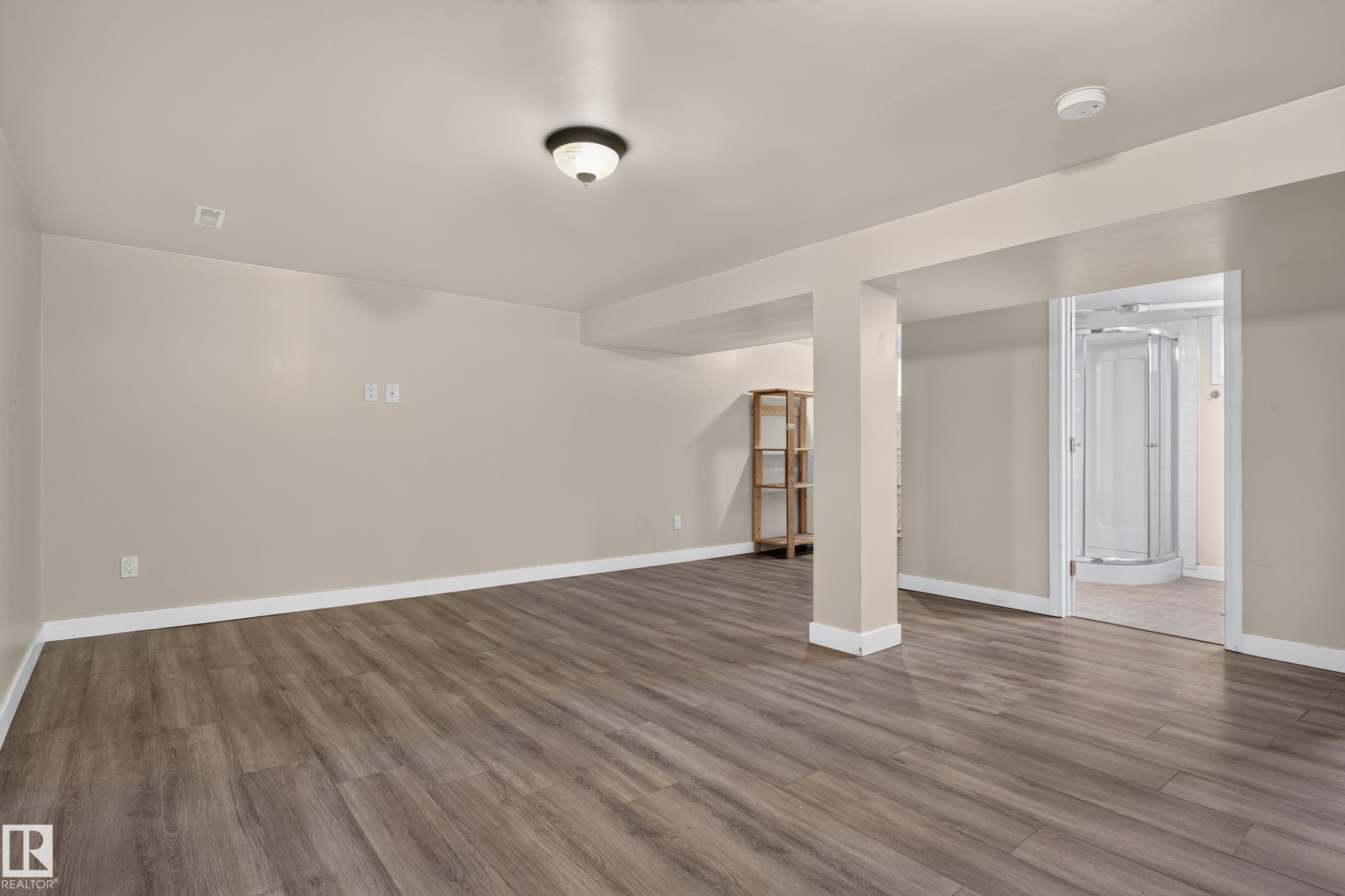 Spacious room with wood-finish flooring, recessed ceiling lighting, and a neutral color palette - 11549 88 Street Nw, Edmonton, AB - Indoor Photo Showing Other Room