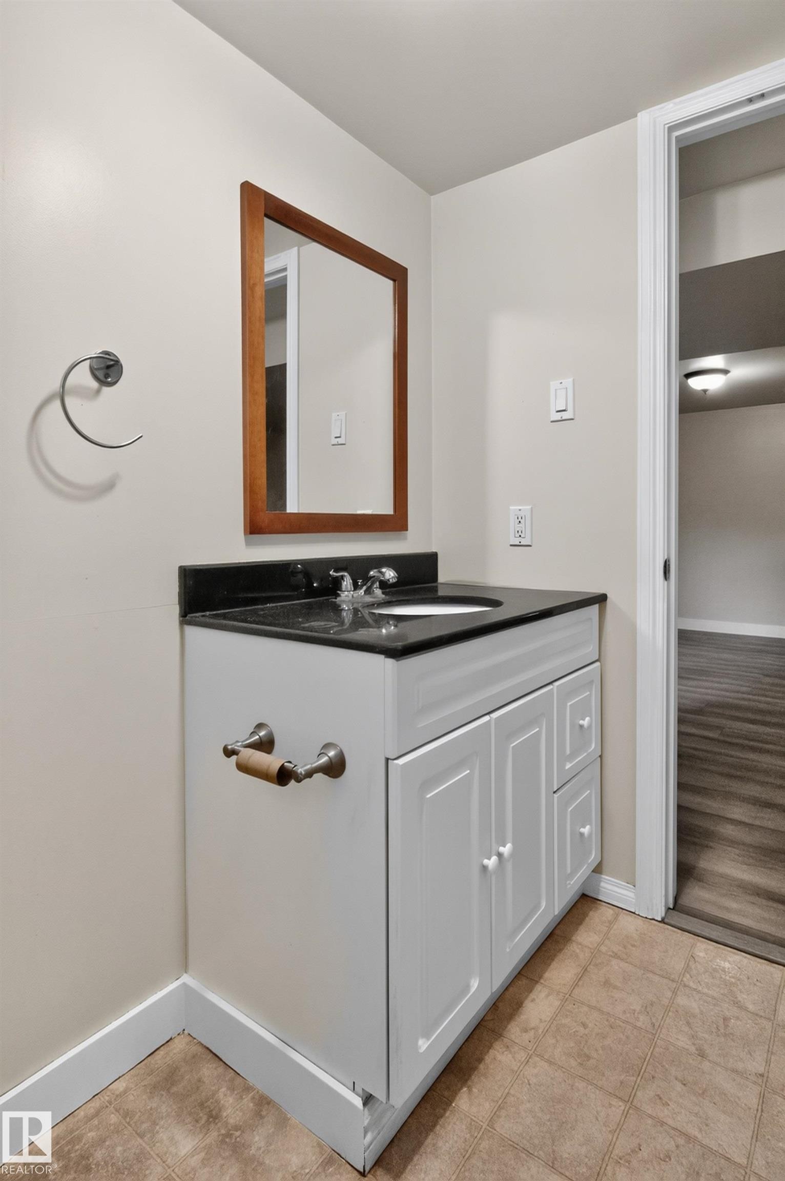 Vanity with white cabinetry, black countertop, and integrated sink - 11549 88 Street Nw, Edmonton, AB - Indoor Photo Showing Bathroom