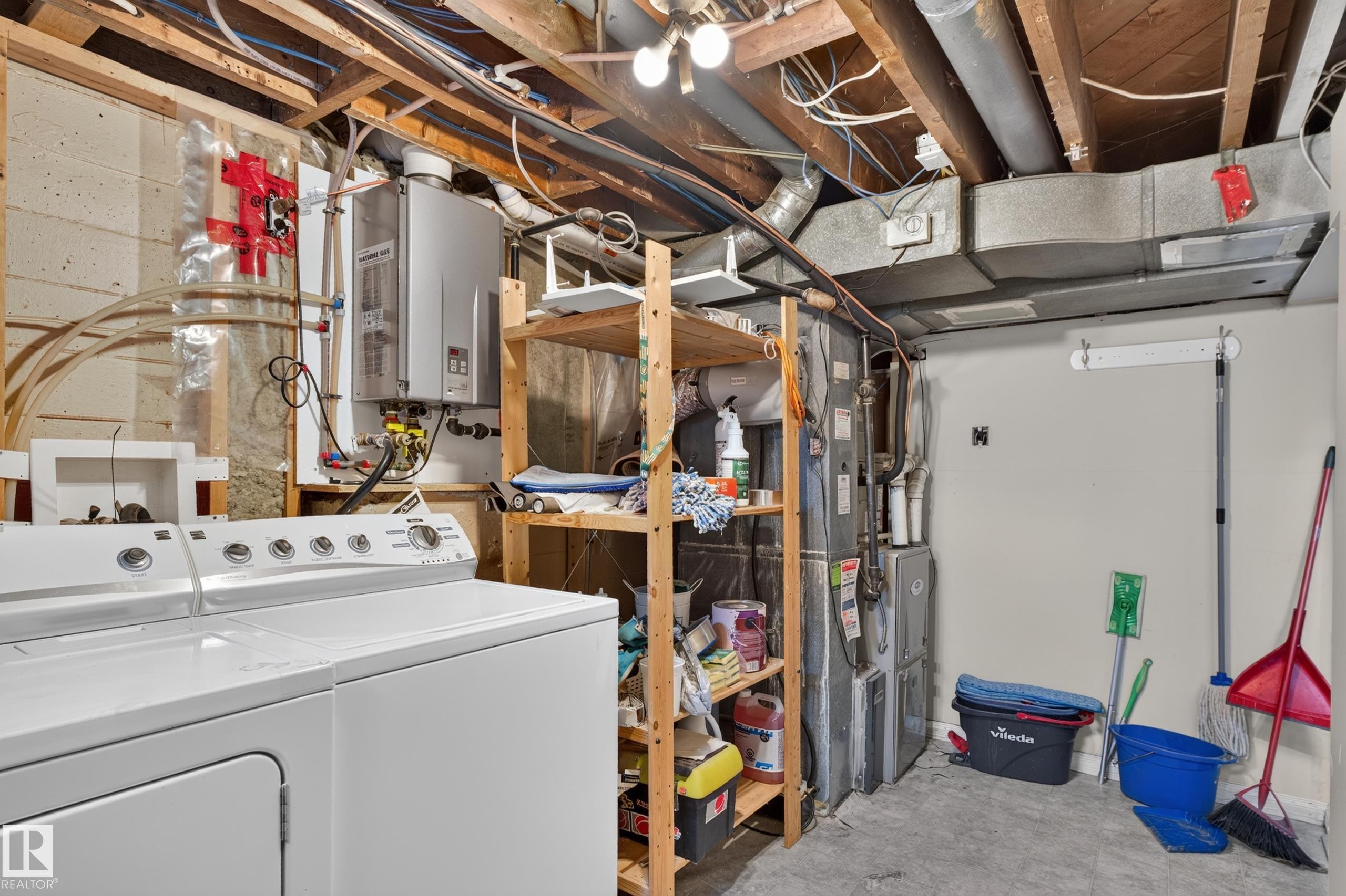Utility space with exposed ceiling joists, concrete block wall, and concrete flooring - 11549 88 Street Nw, Edmonton, AB - Indoor Photo Showing Laundry Room