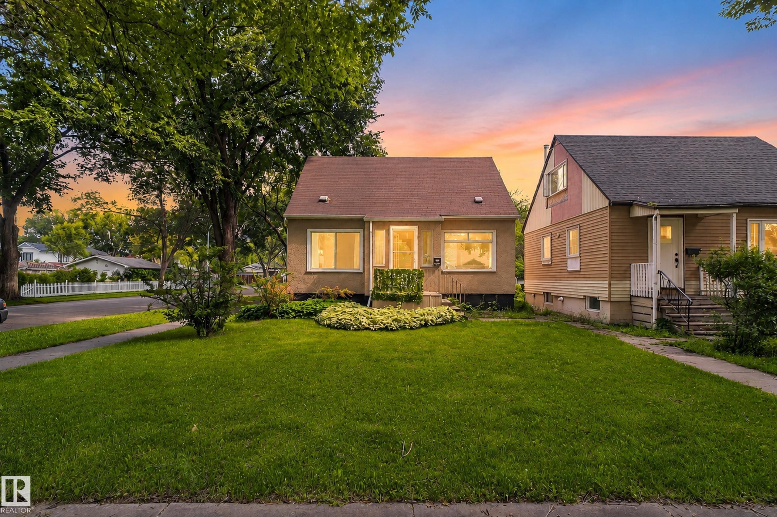 Front exterior with a pitched roof, stucco siding, and a landscaped front yard with a mature tree - 11549 88 Street Nw, Edmonton, AB - Outdoor