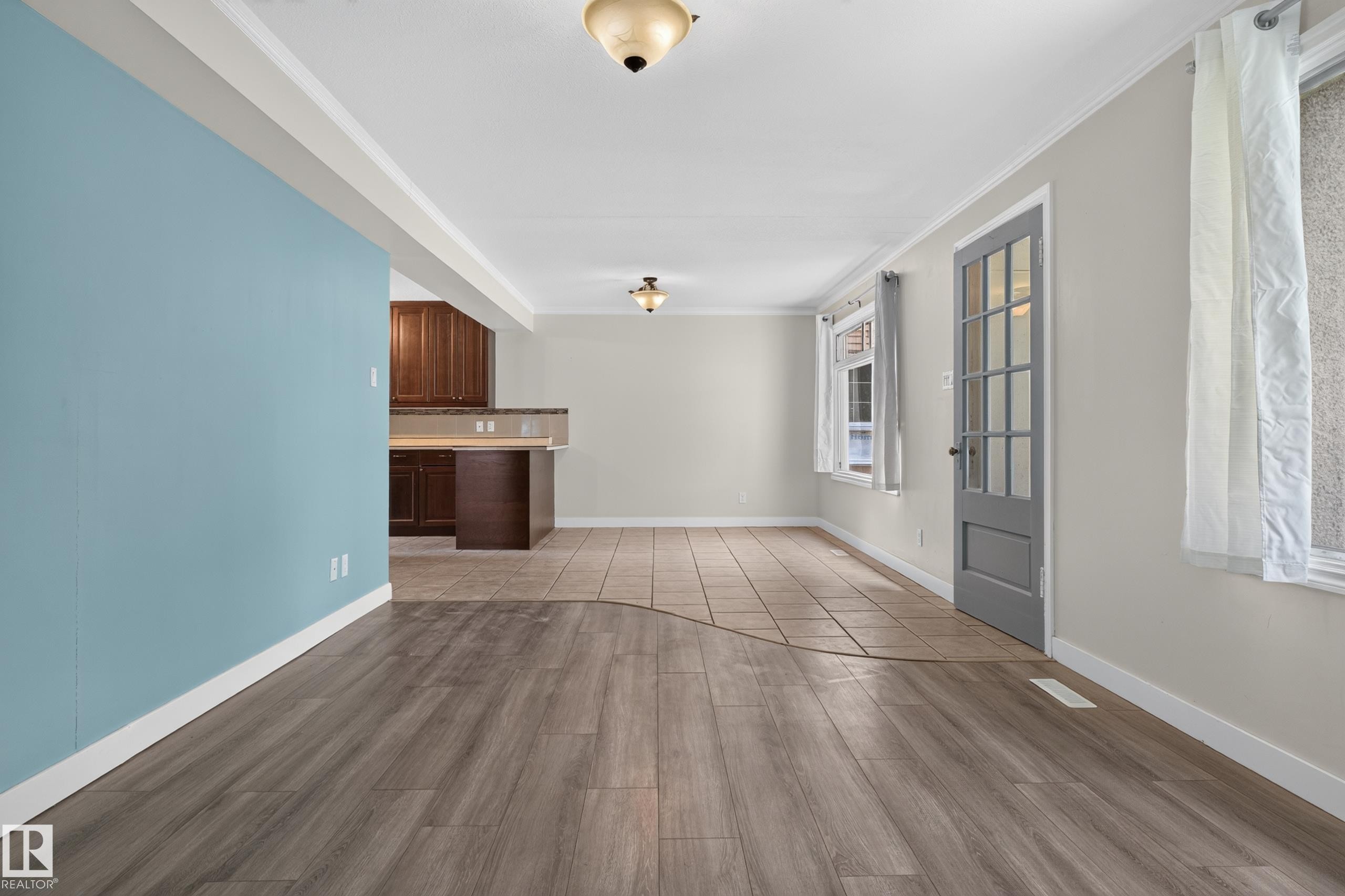 Wood-finish flooring, tiled flooring, built-in cabinetry, and a paneled door with glass inserts - 11549 88 Street Nw, Edmonton, AB - Indoor Photo Showing Other Room