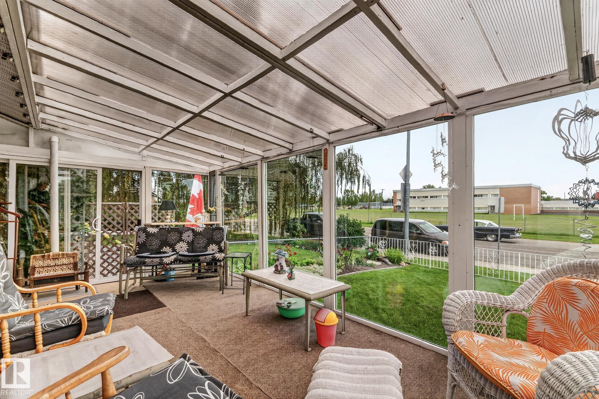 Enclosed porch featuring a transparent roof, expansive windows, and a carpeted floor - 13432 134 Street Nw, Edmonton, AB - With Deck Patio Veranda With Exterior