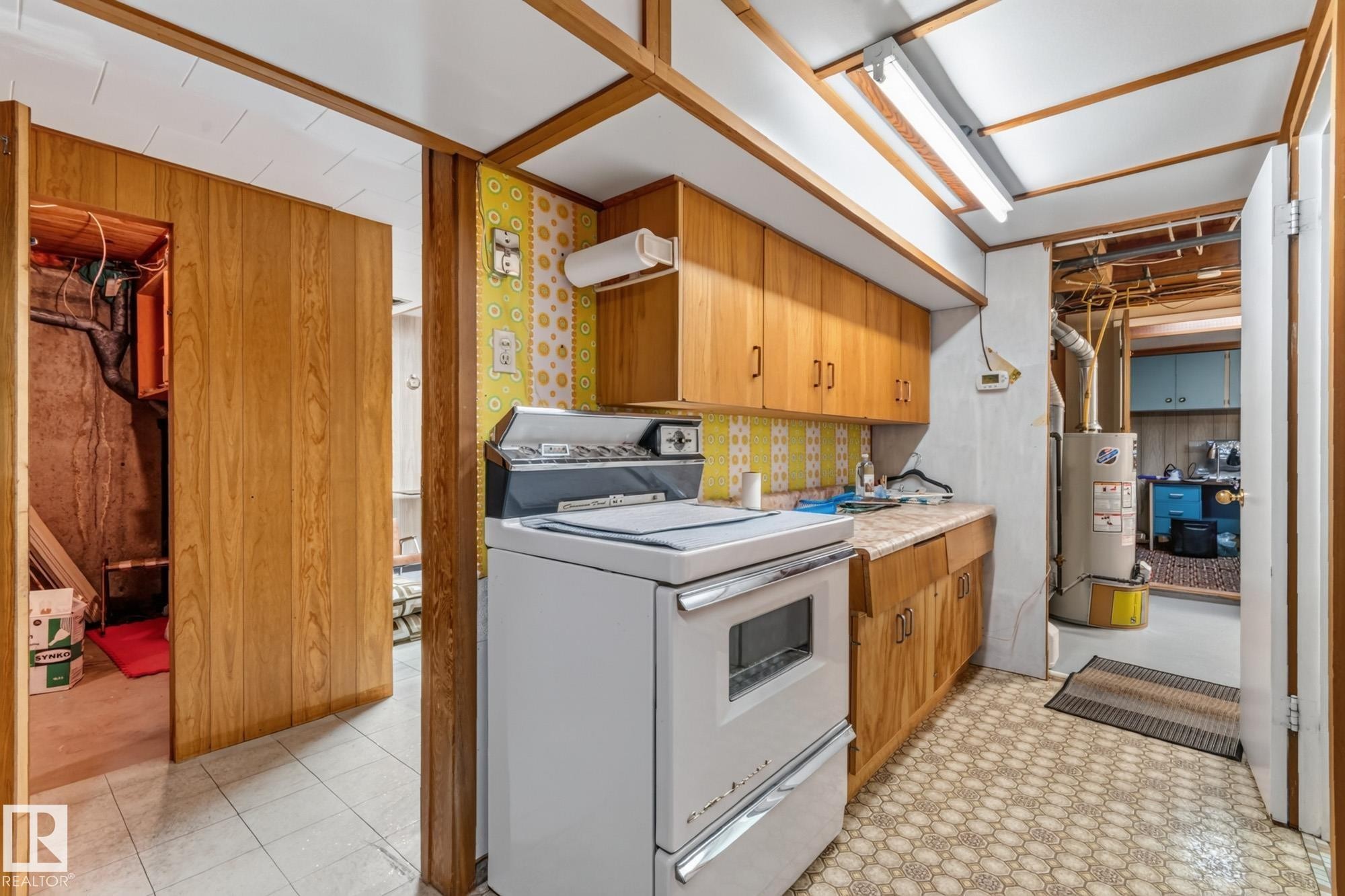 Wood-finish cabinetry and trim throughout, with patterned tile flooring - 13432 134 Street Nw, Edmonton, AB - Indoor Photo Showing Other Room