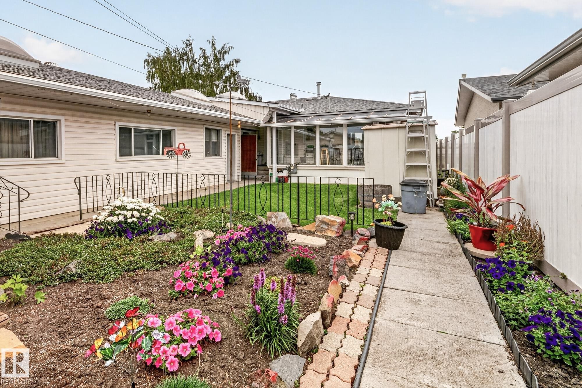 Manicured front yard with diverse plantings and a concrete walkway - 13432 134 Street Nw, Edmonton, AB - Outdoor