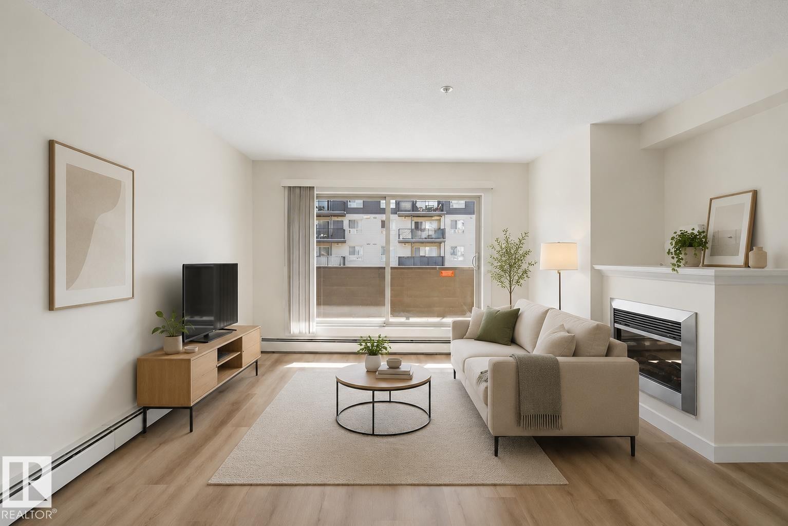 Living area with wood-finish flooring, a built-in fireplace, and a large window - #226 17011 67 Av Nw, Edmonton, AB - Indoor With Fireplace