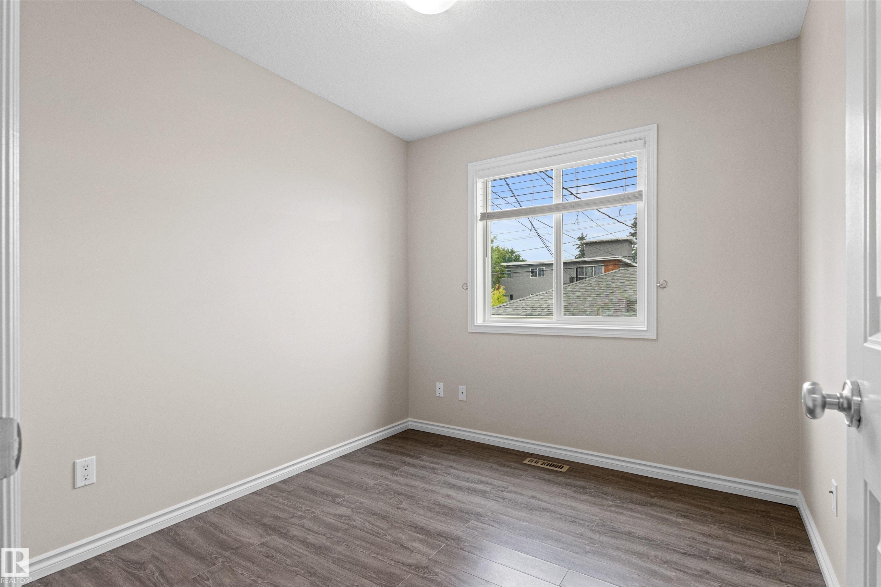 Bright room featuring wood-finish flooring and a large window with white blinds - 10634 155 Street Nw, Edmonton, AB - Indoor Photo Showing Other Room