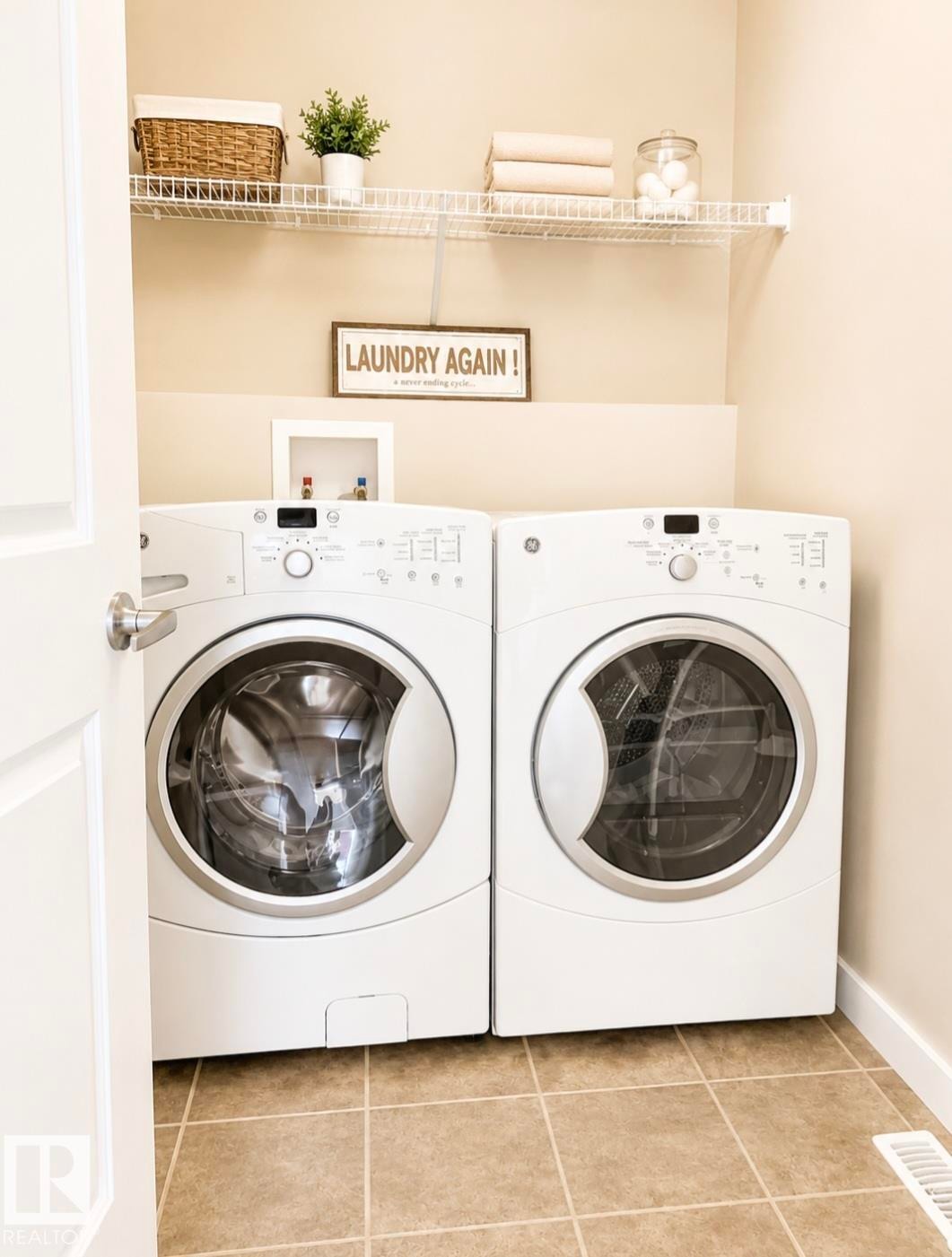 Laundry area featuring tile flooring, neutral wall color, and a built-in wire shelf - 5135 1A Avenue Sw, Edmonton, AB
