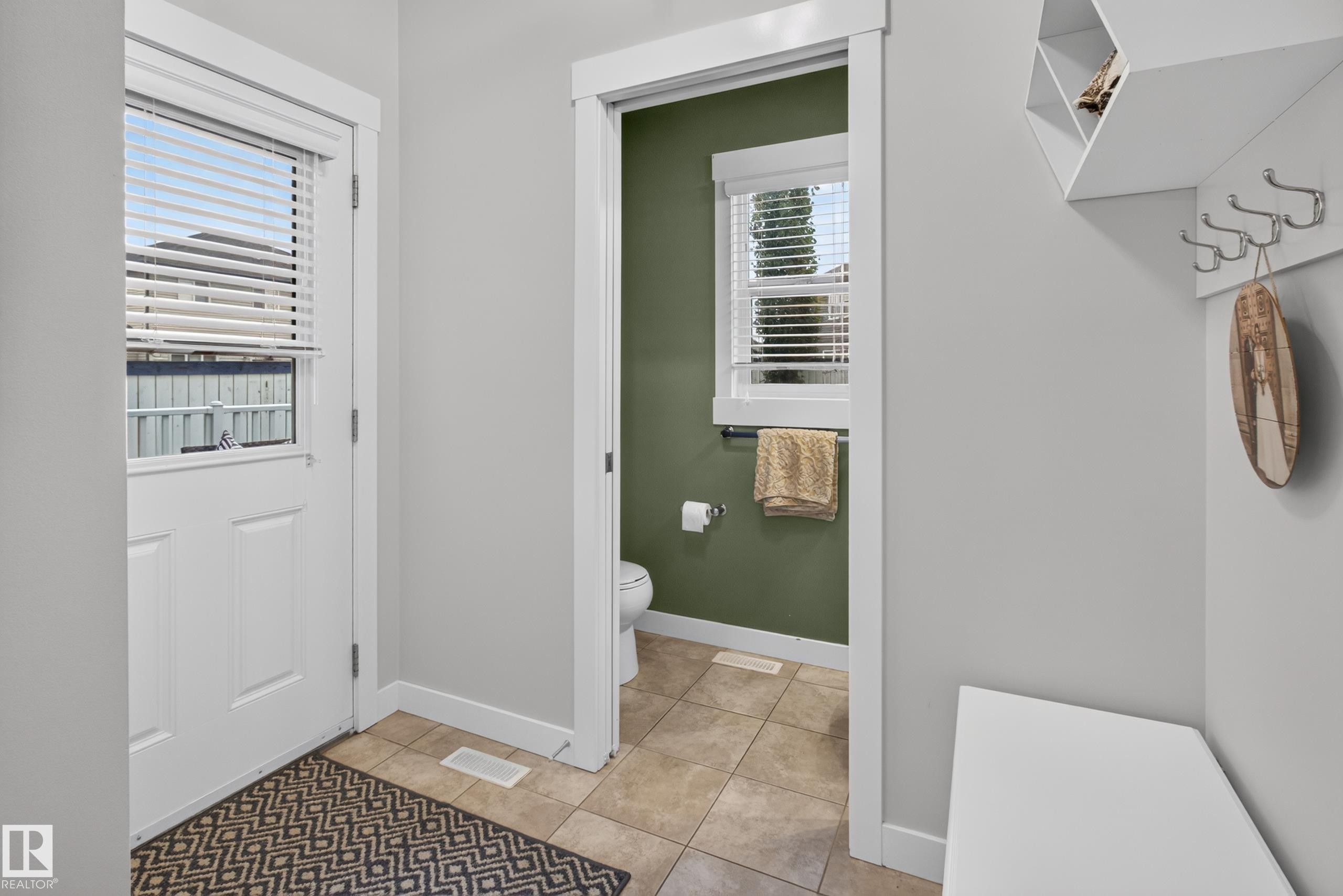 Entryway featuring a white paneled door with an integrated window and blinds, light gray wall paint, and a built-in storage bench with an overhead shelf and coat hooks - 17305 73 Street Nw, Edmonton, AB - Indoor Photo Showing Other Room