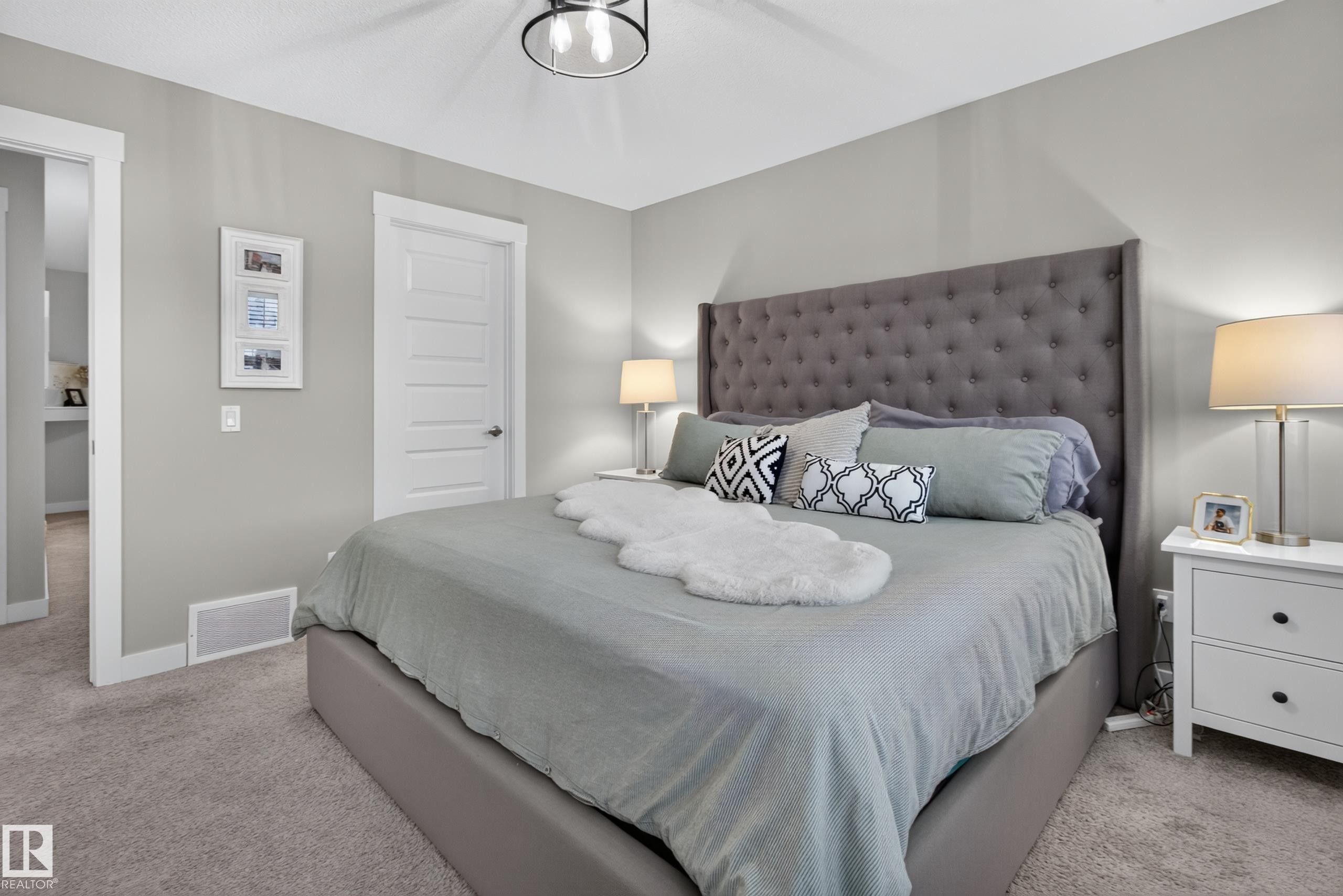 Spacious room featuring neutral wall tones, plush carpeting, a contemporary ceiling fixture, white trim, and a paneled interior door - 17305 73 Street Nw, Edmonton, AB - Indoor Photo Showing Bedroom