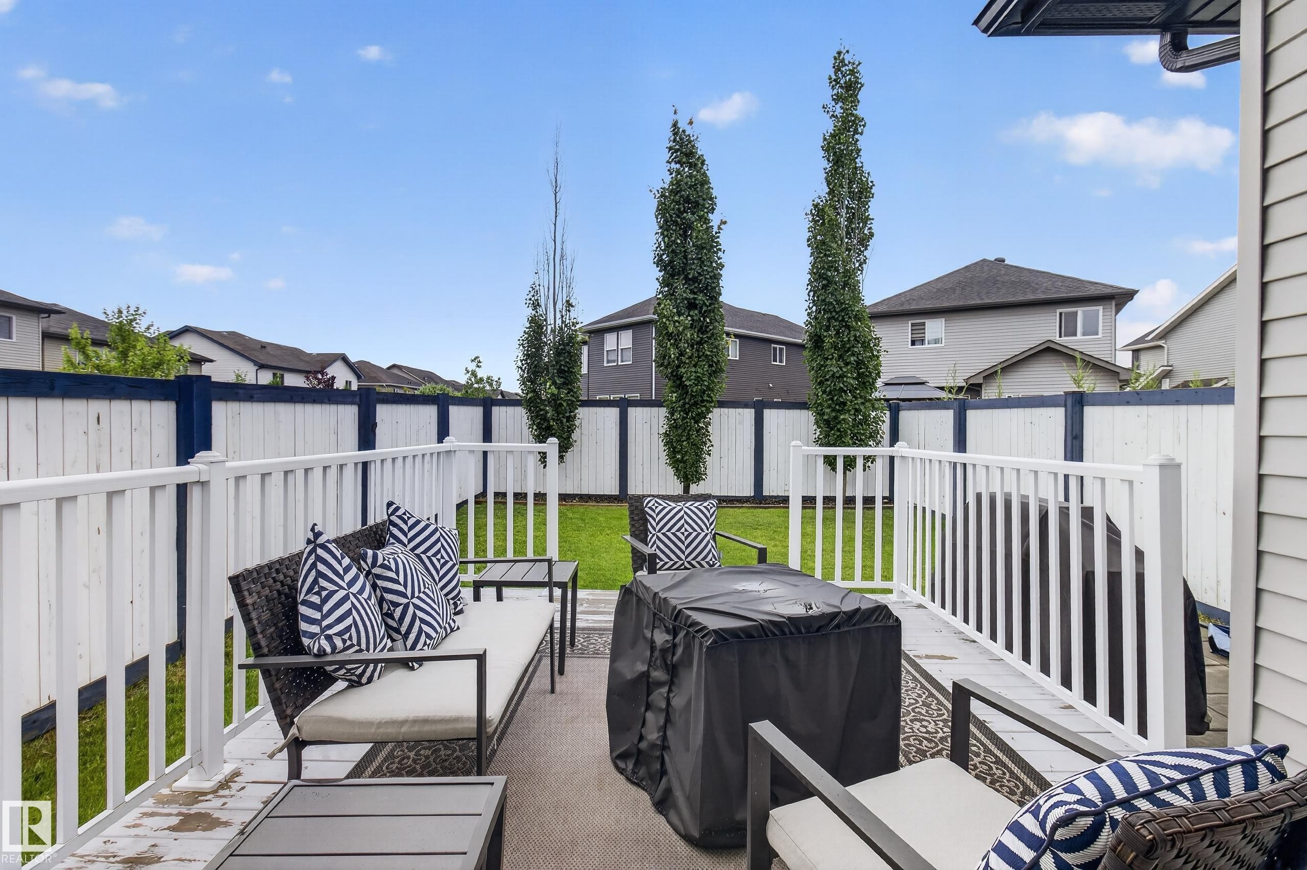 Deck with white railing and privacy fencing enclosing a grass lawn with mature trees - 17305 73 Street Nw, Edmonton, AB - Outdoor With Deck Patio Veranda With Exterior