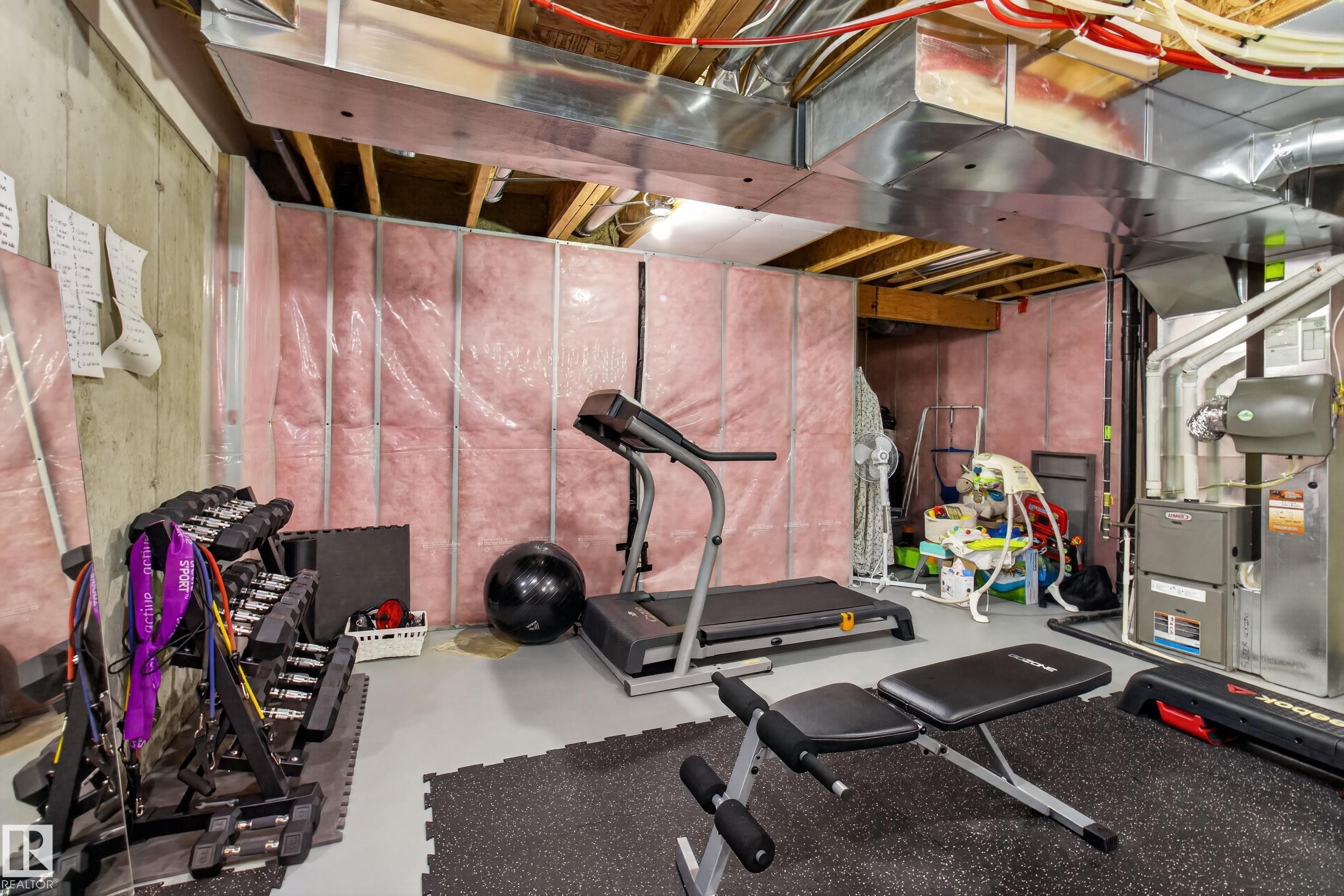 Unfinished basement space featuring visible insulation, concrete walls, exposed ductwork, exposed ceiling joists, and a utility area with mechanical systems - 17305 73 Street Nw, Edmonton, AB - Indoor Photo Showing Gym Room