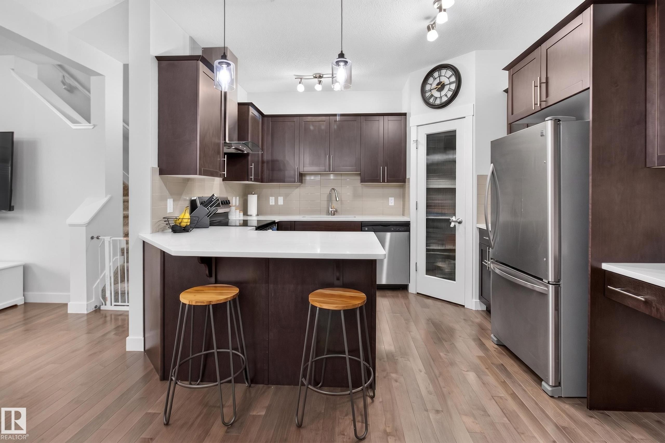 Contemporary kitchen with wood-finish flooring and dark wood cabinetry - 17305 73 Street Nw, Edmonton, AB - Indoor Photo Showing Kitchen With Stainless Steel Kitchen With Upgraded Kitchen