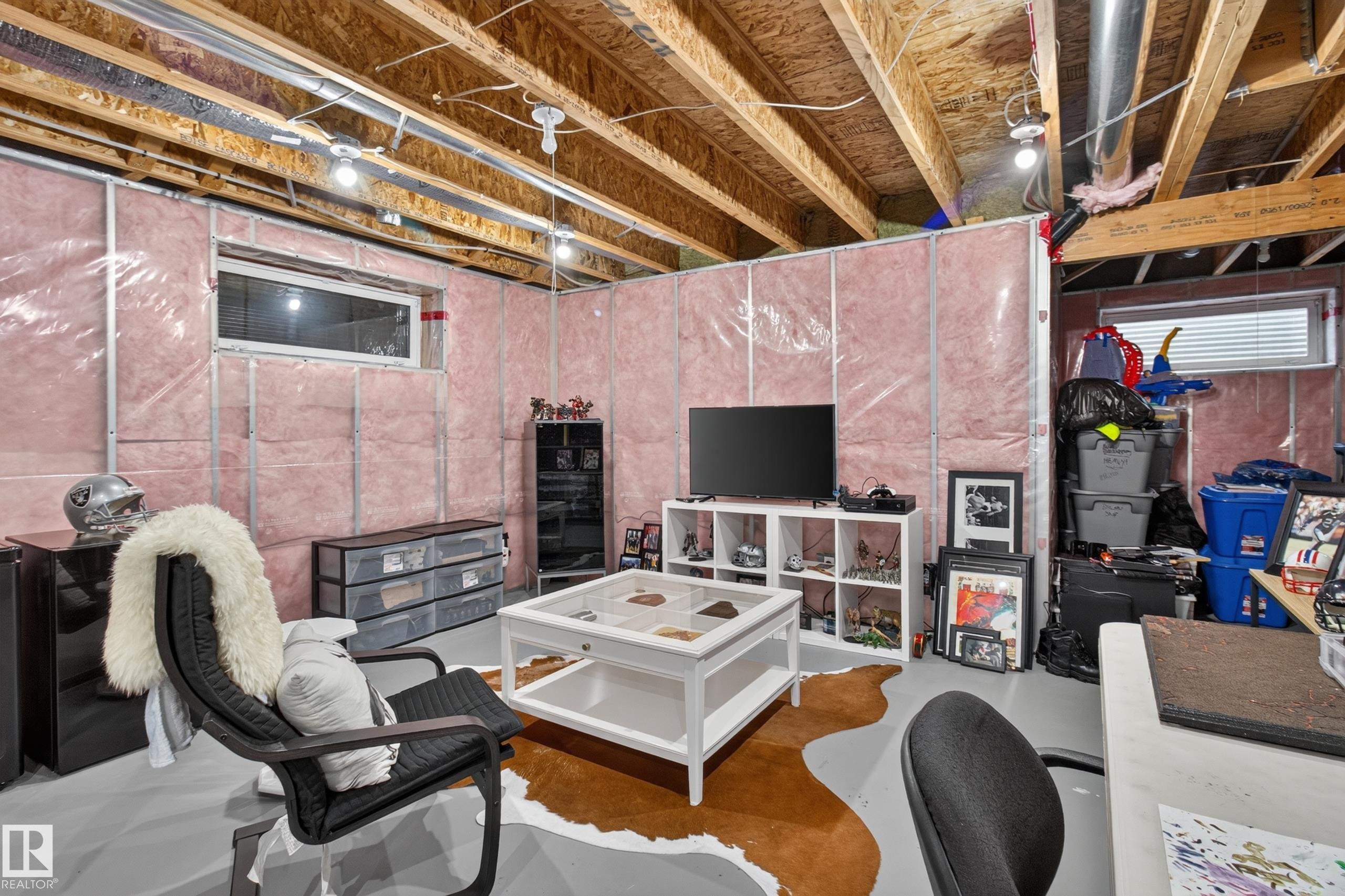 Unfinished basement area featuring exposed ceiling joists, insulation-wrapped walls, and painted concrete flooring - 17305 73 Street Nw, Edmonton, AB - Indoor Photo Showing Basement