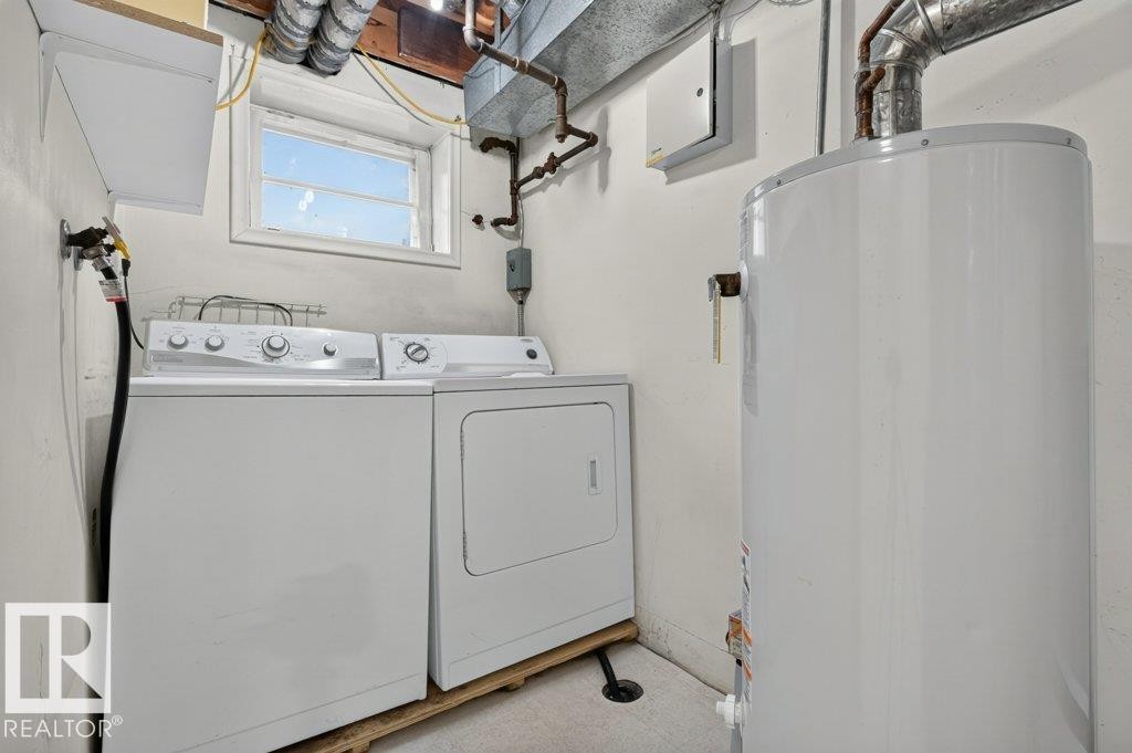 Dedicated laundry area featuring a white washing machine and dryer, a water heater, and a window - 9026 92 Street Nw, Edmonton, AB - Indoor Photo Showing Laundry Room