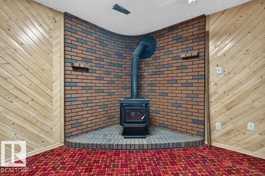 Corner brick-clad wood-burning stove with a matching brick hearth - 9026 92 Street Nw, Edmonton, AB - Indoor Photo Showing Other Room With Fireplace