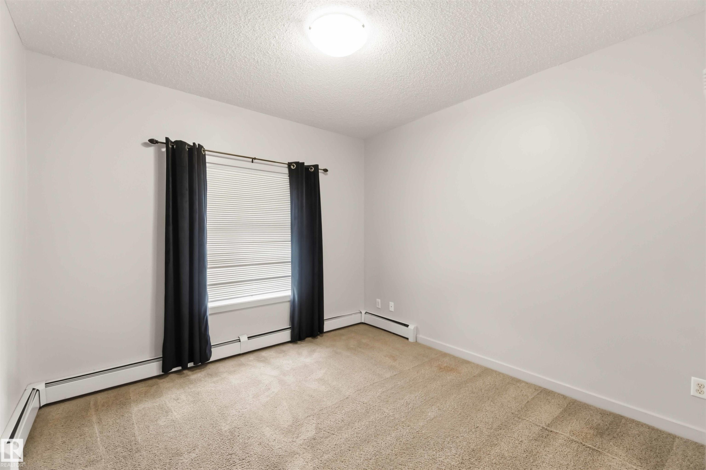 Neutral wall color with textured ceiling - #414 5510 Schonsee Dr Nw, Edmonton, AB